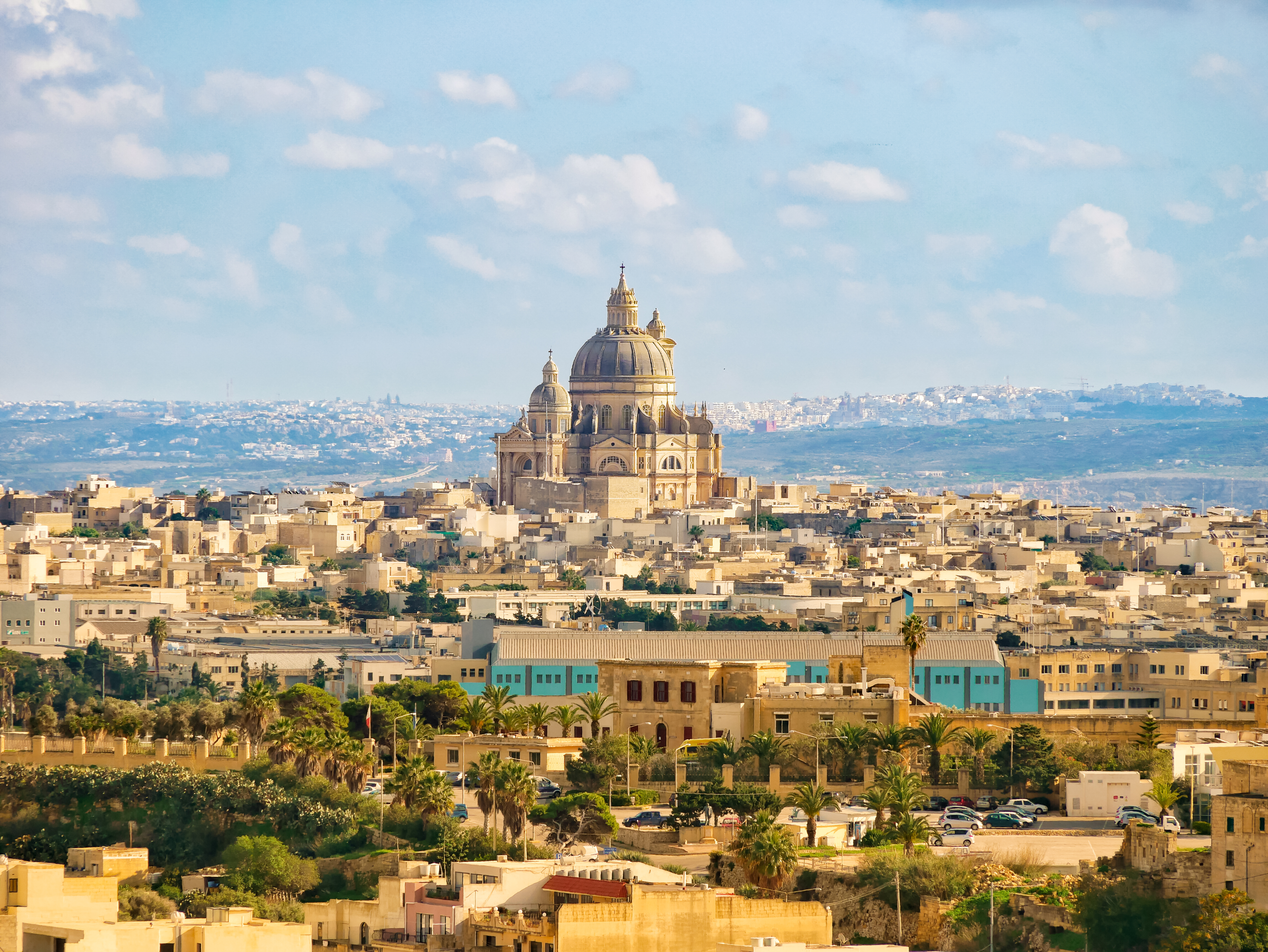 Aerial view of a historic Maltese city with a grand domed cathedral.