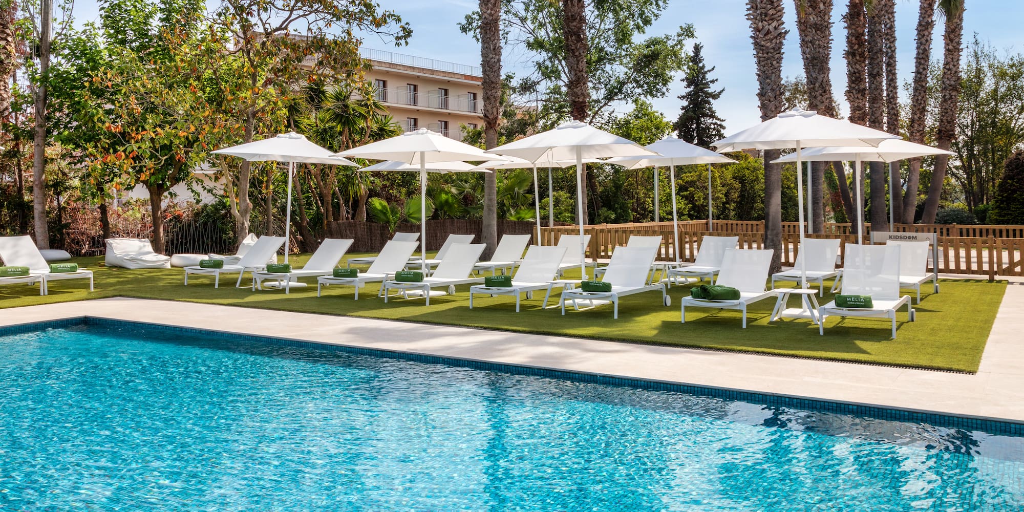 a pool with white umbrellas and lounge chairs