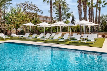 a pool with white umbrellas and lounge chairs