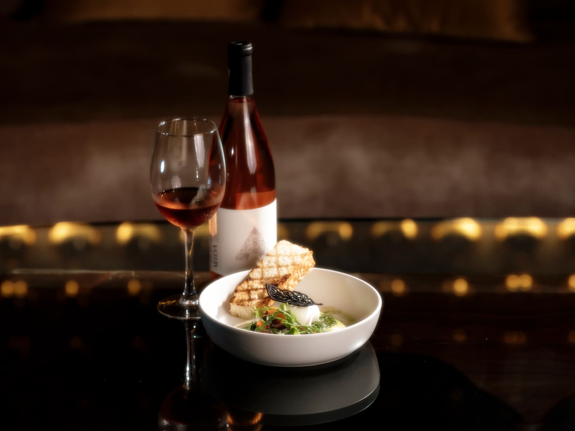 a bowl of food and a glass of wine