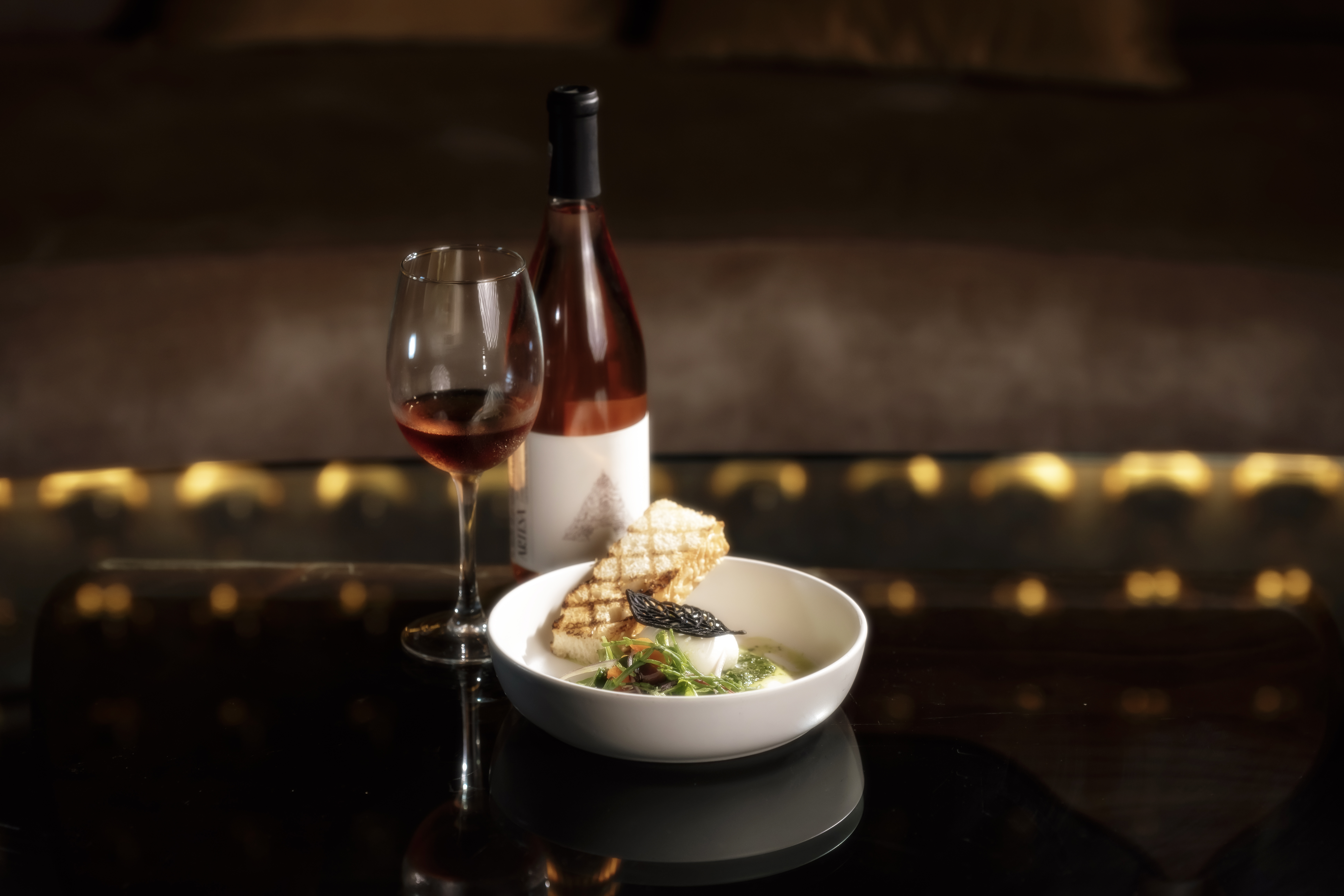 a bowl of food and a glass of wine