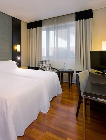 a room with a bed and a table and chairs