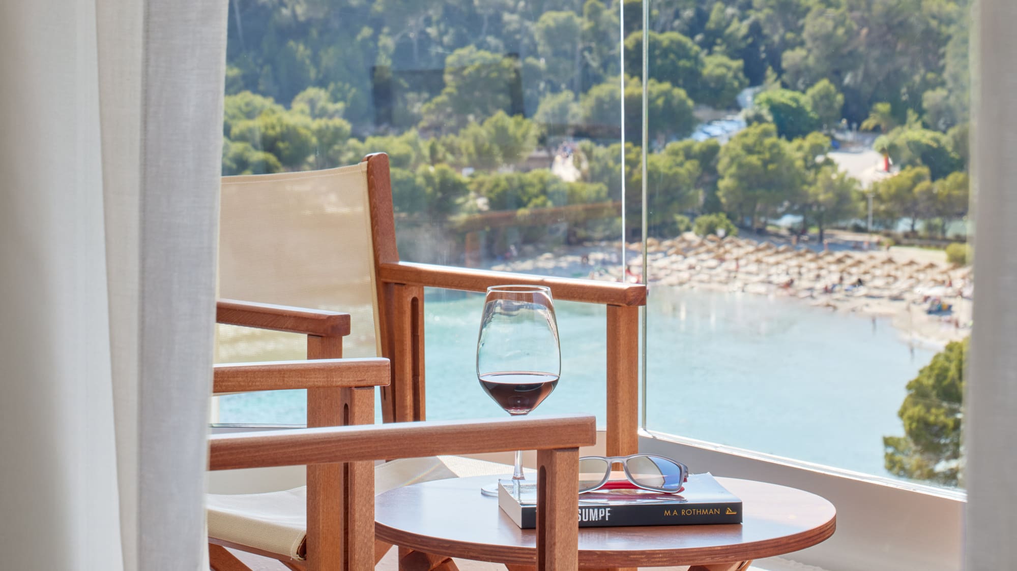 a table and chairs on a balcony overlooking a beach
