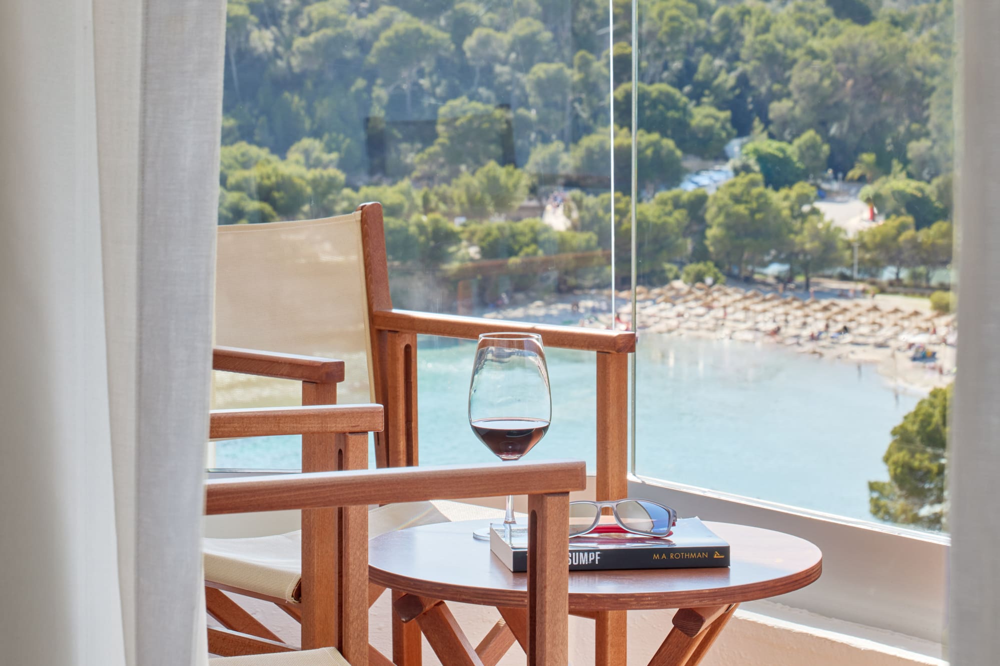 a table and chairs on a balcony overlooking a beach