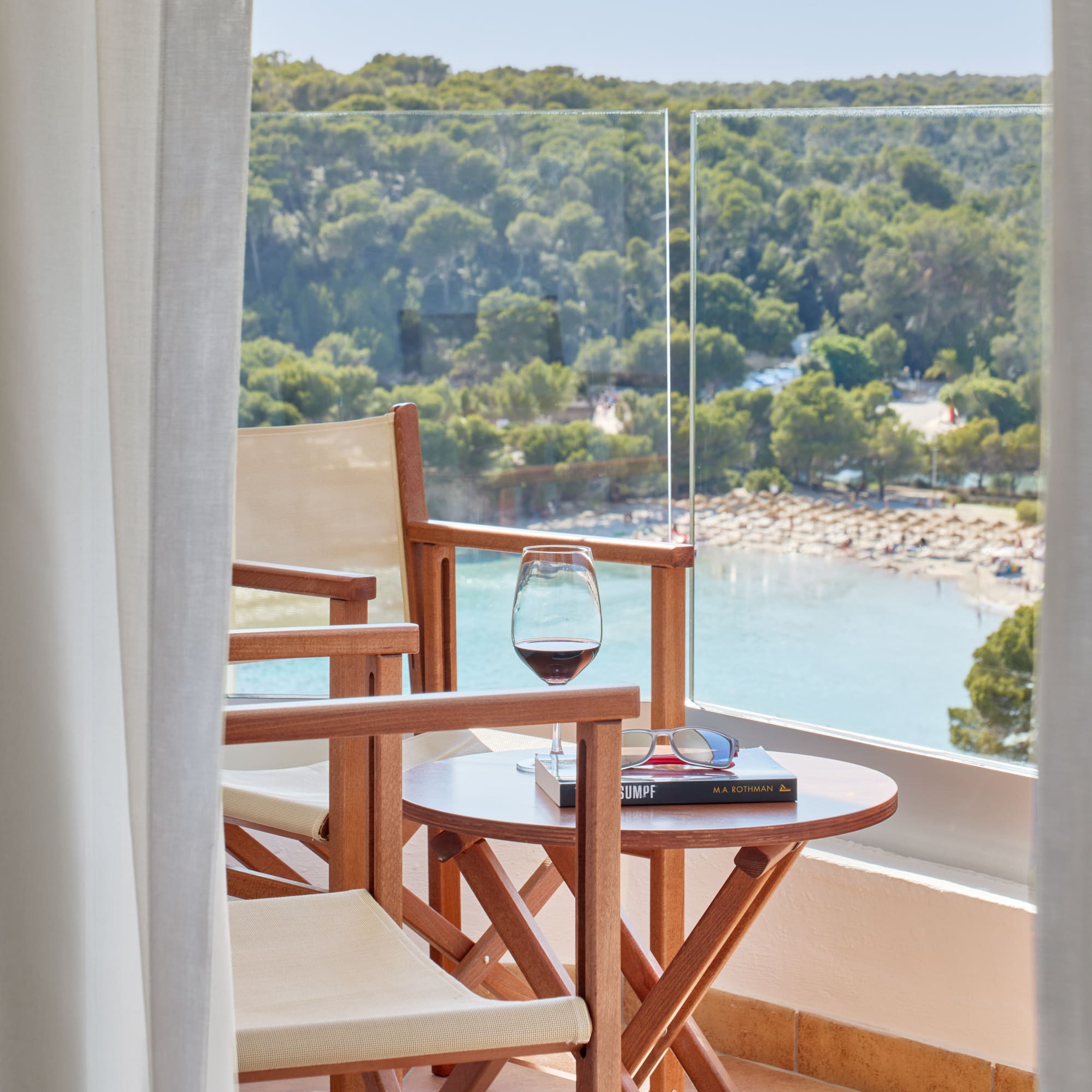 a table and chairs on a balcony overlooking a beach