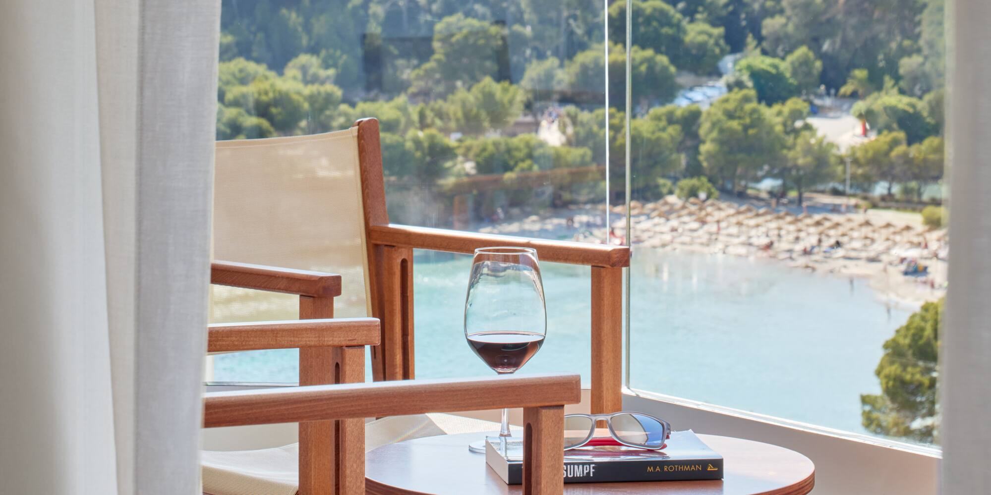 a table and chairs on a balcony overlooking a beach