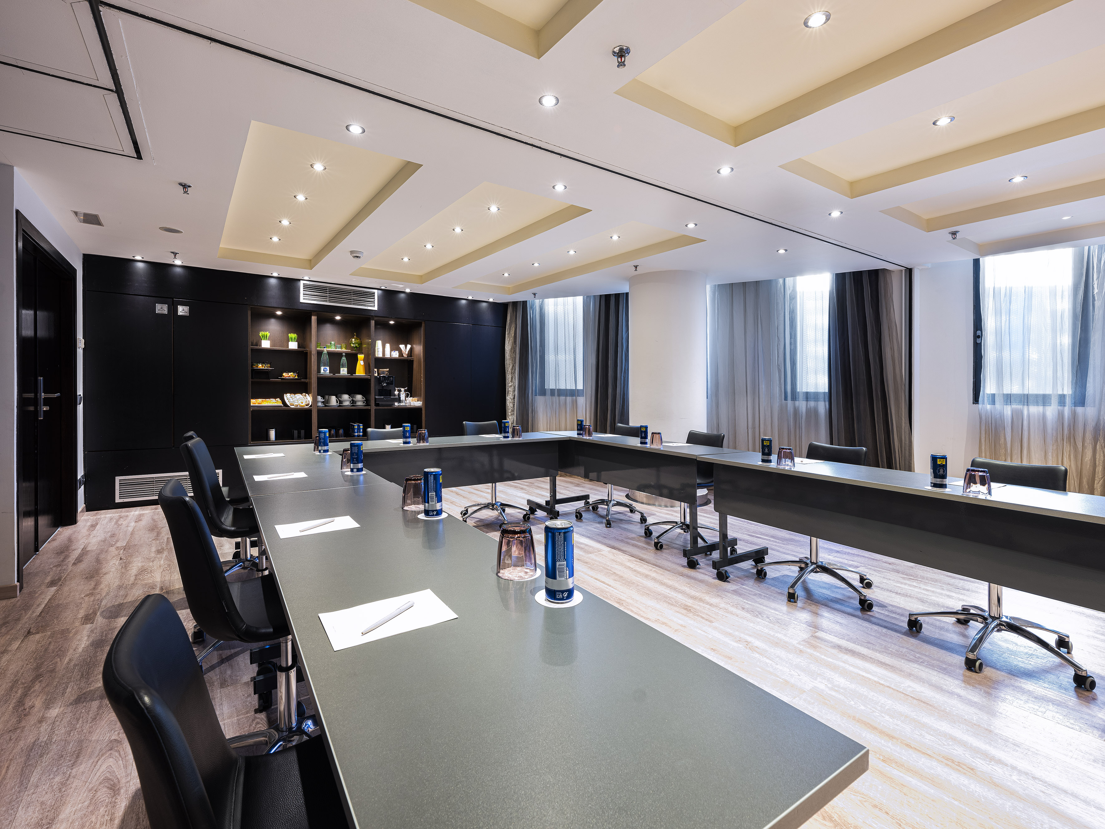 Modern business meeting room with U-shaped table, chairs, and refreshment area. - BARCELONETA - فندق برشلونة كوندال مار(Condal Mar) المنتسب لـ Melia, برشلونة