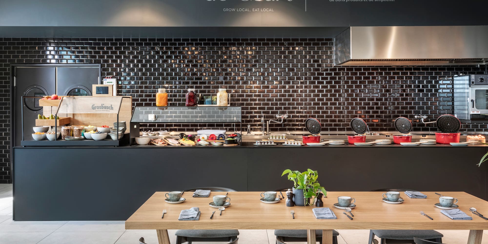 de Gaart modern breakfast buffet with local food, black tiles, and set table.