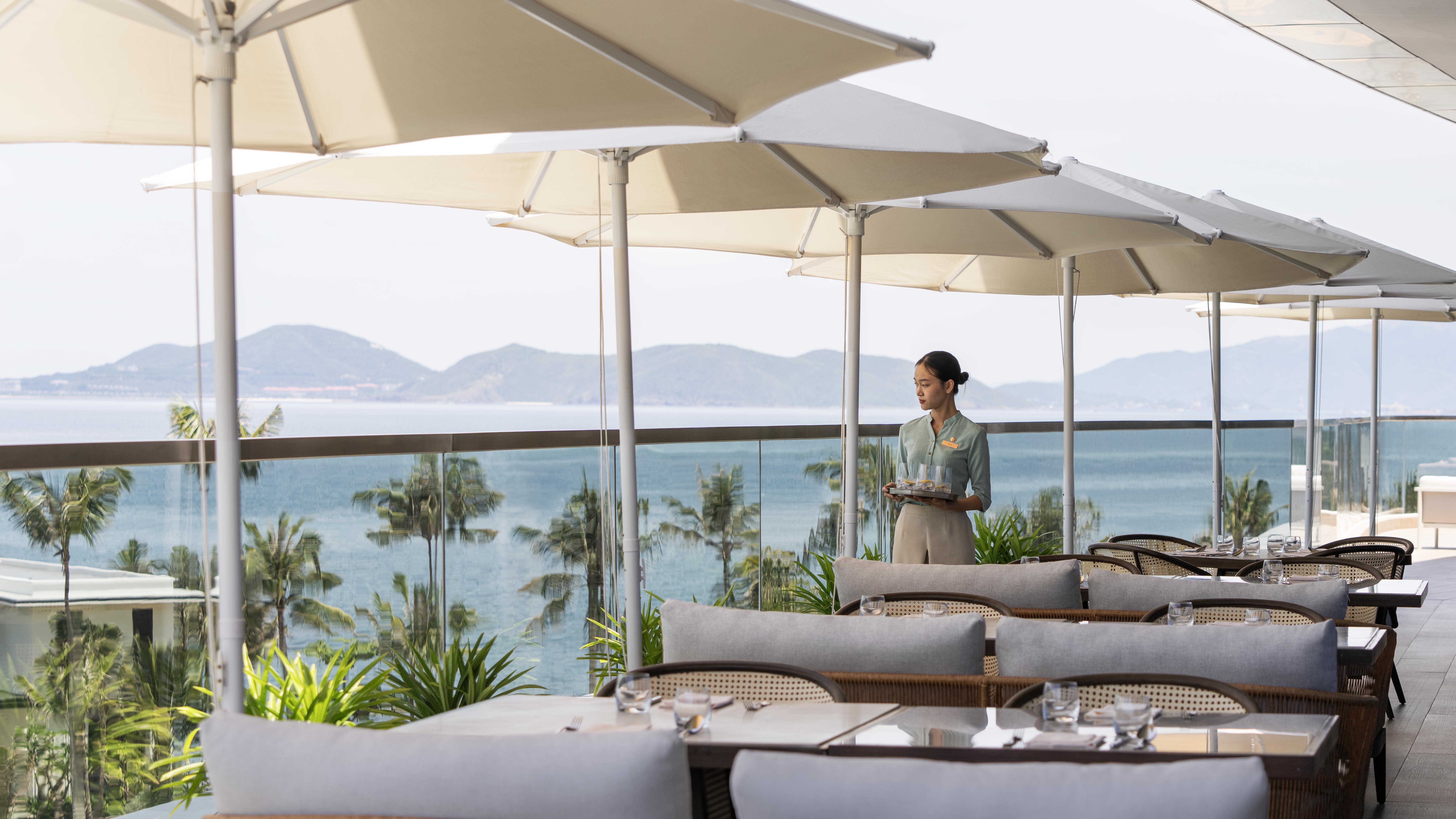 a woman holding a tray of food under umbrellas
