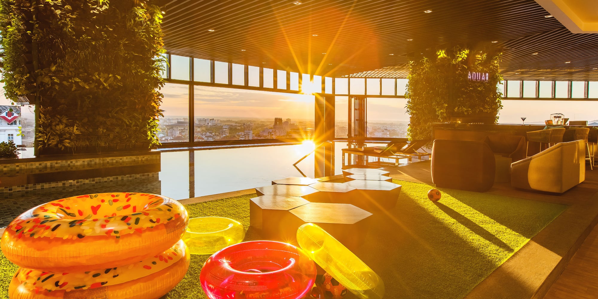 a pool area with pool toys and a view of the city from the window
