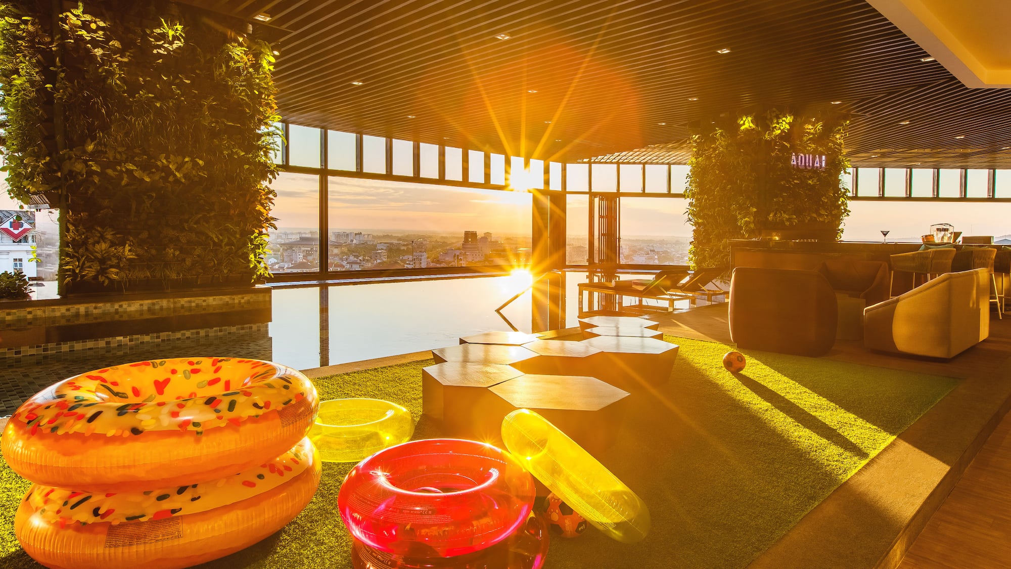 a pool area with pool toys and a view of the city from the window