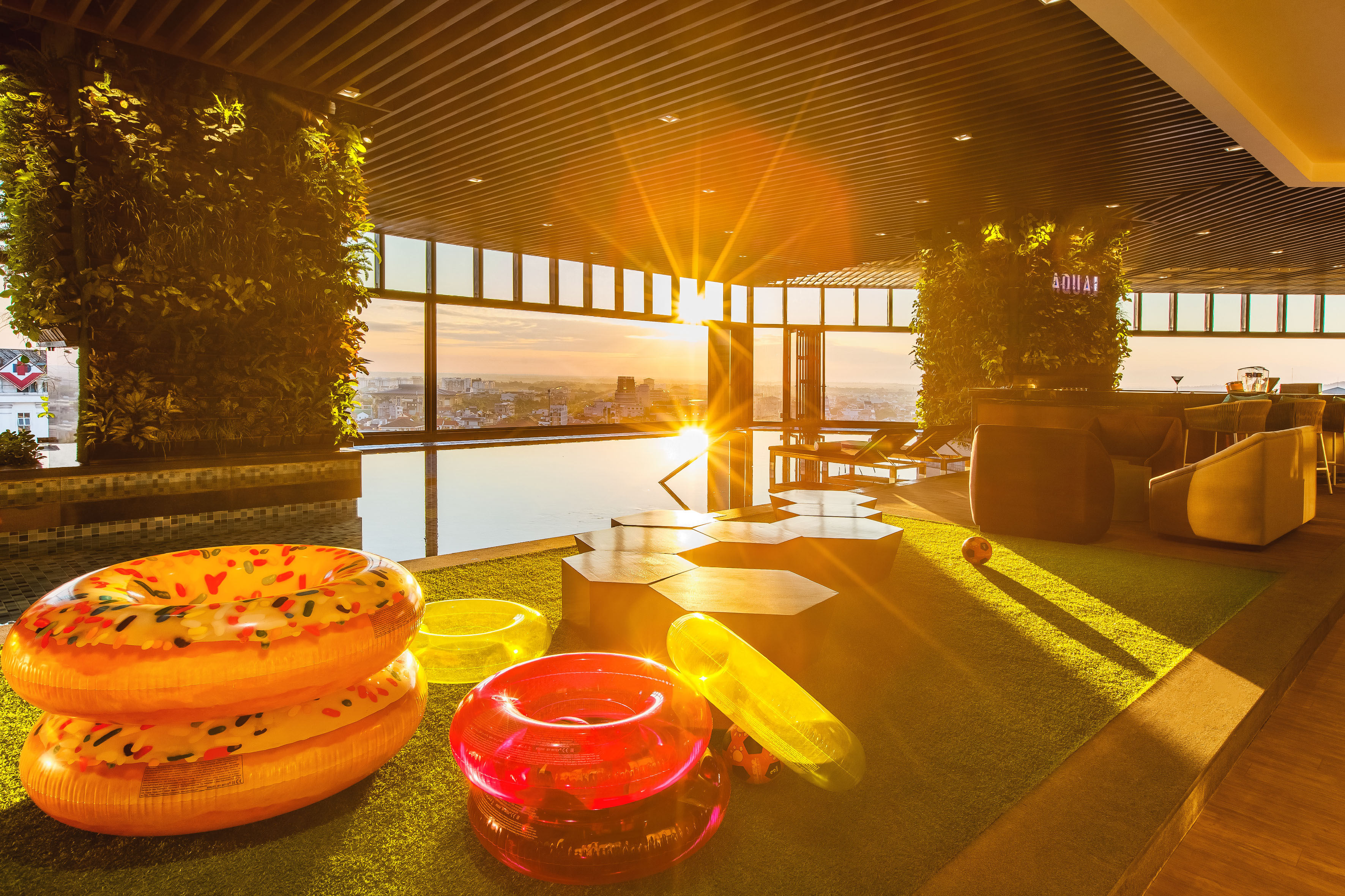 a pool area with pool toys and a view of the city from the window