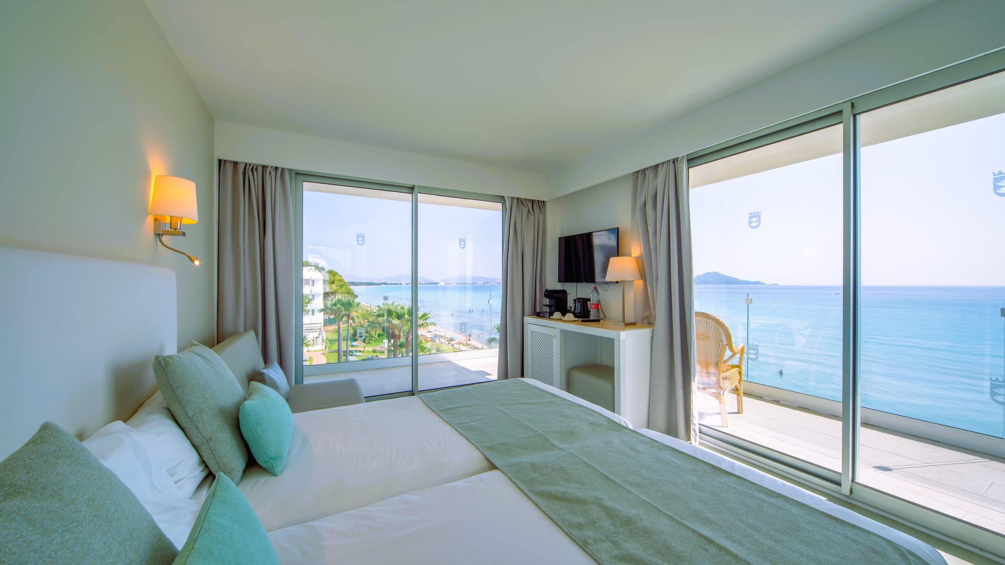 a room with a large bed and a glass door with a view of the ocean