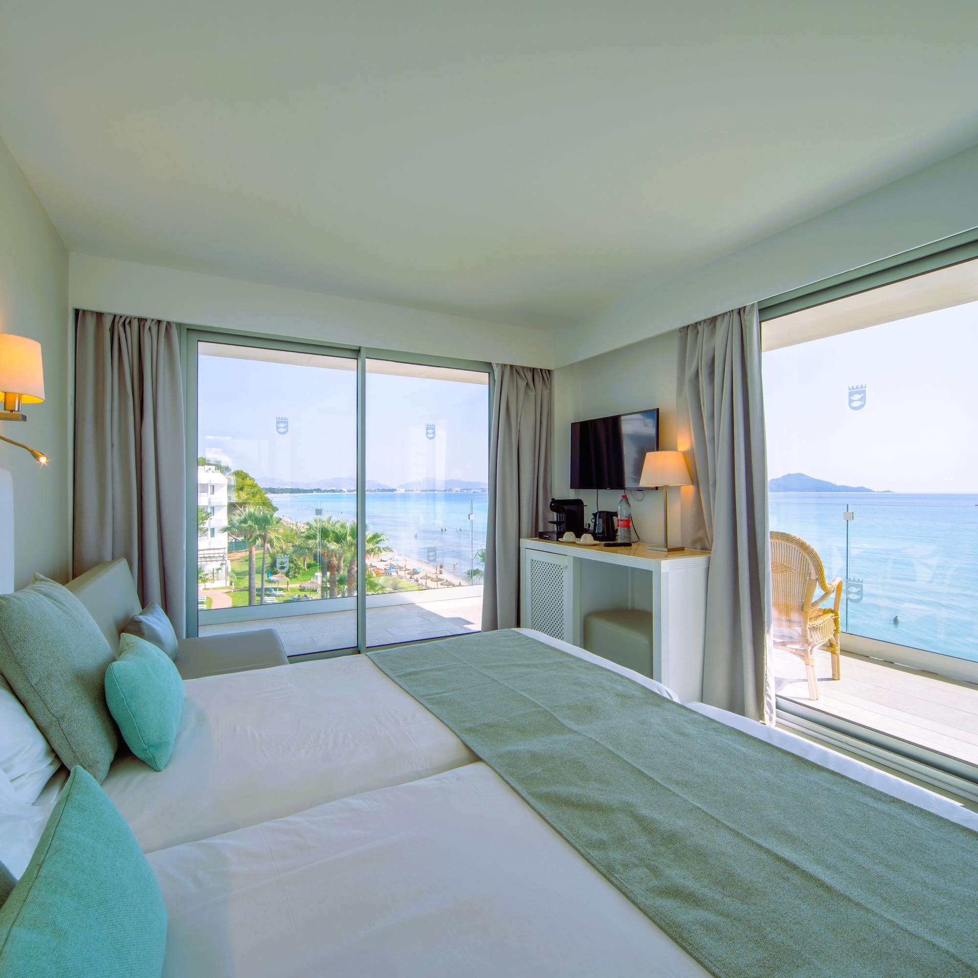 a room with a large bed and a glass door with a view of the ocean