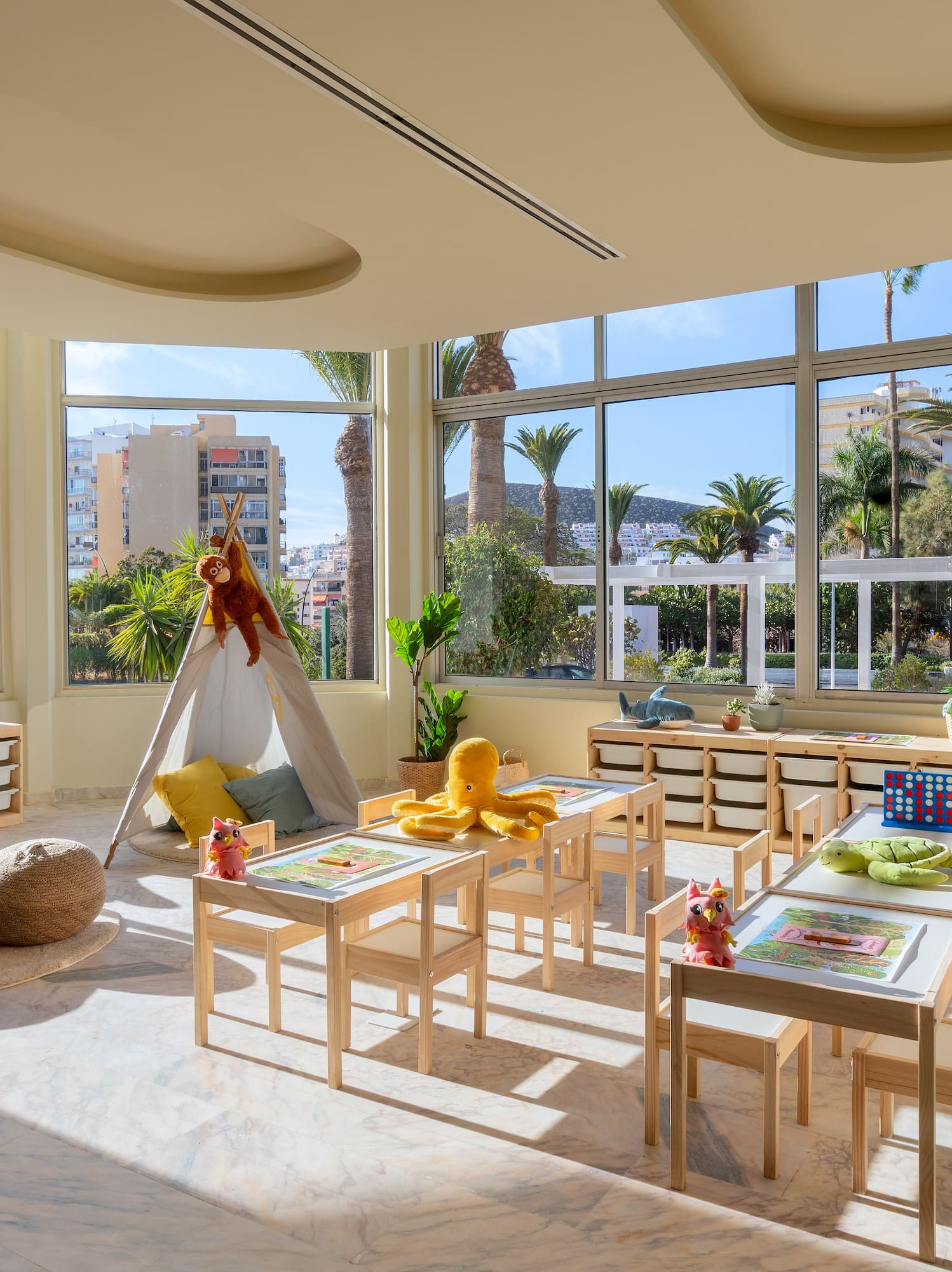 a room with a large window and tables and chairs