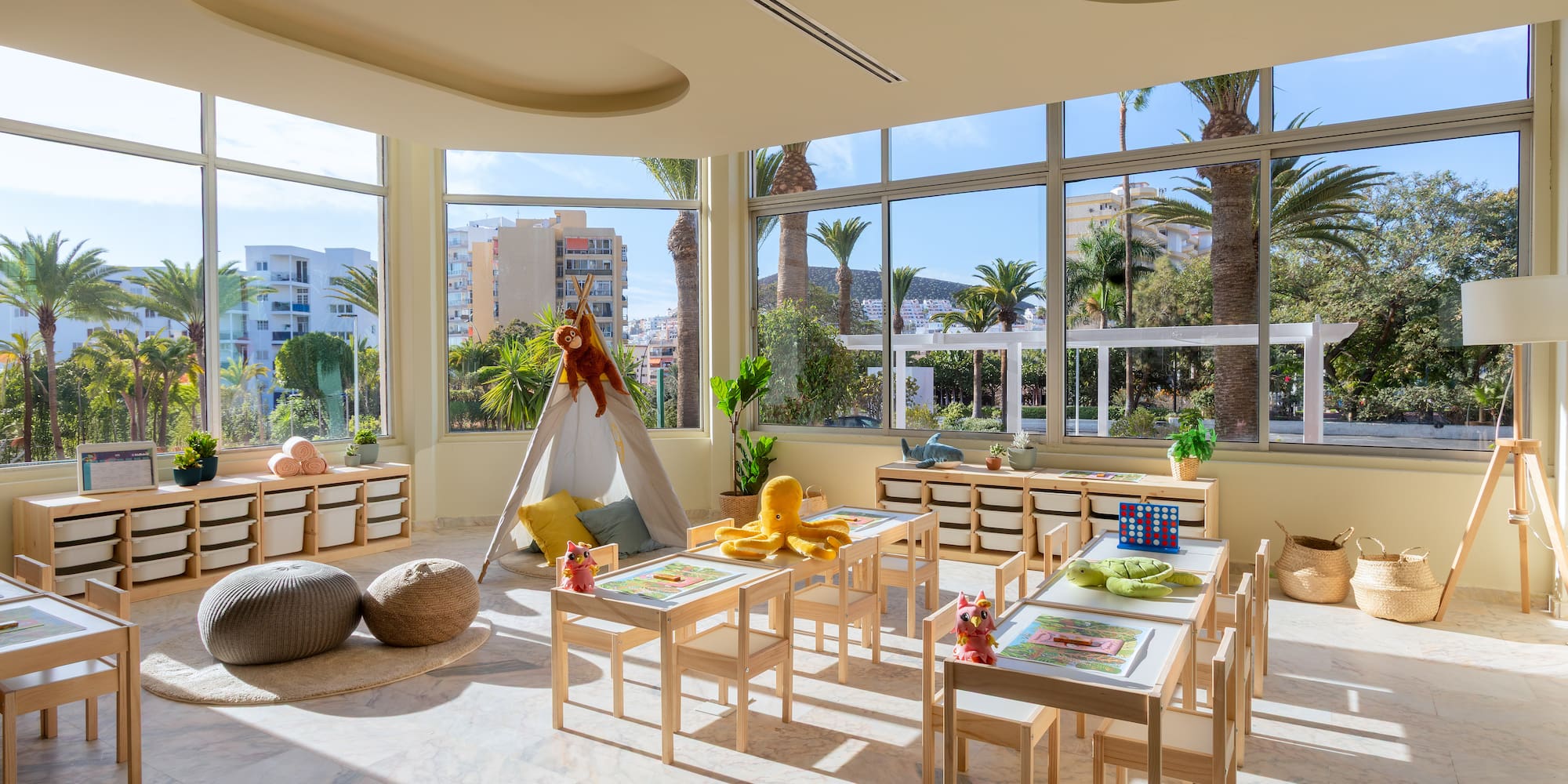 a room with a large window and tables and chairs