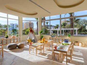 a room with a large window and tables and chairs