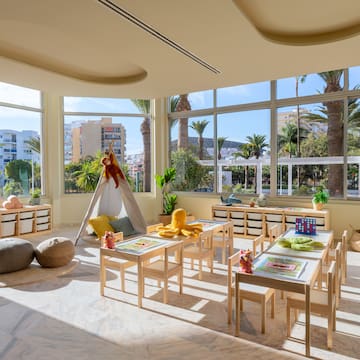 a room with a large window and tables and chairs