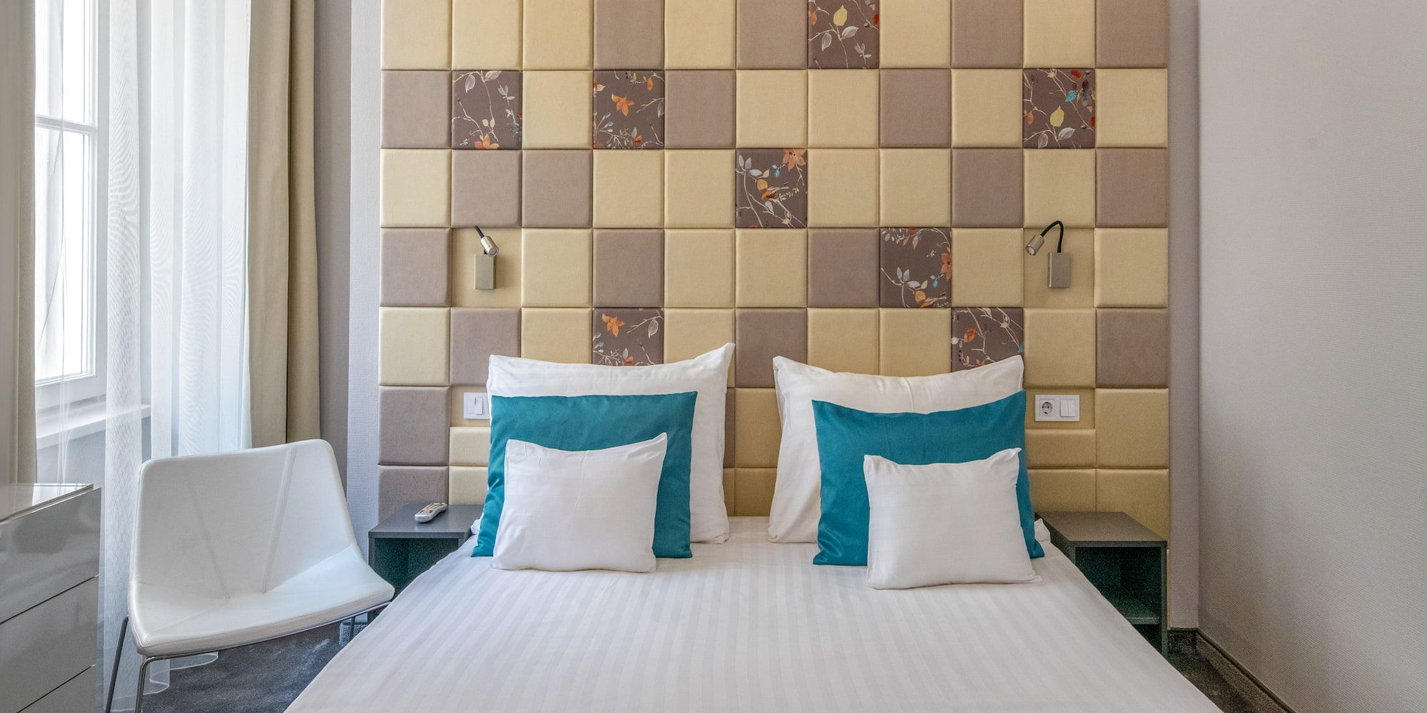 a bed with pillows and a chair in a room