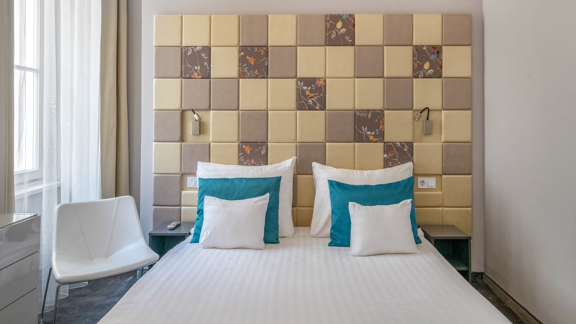 a bed with pillows and a chair in a room