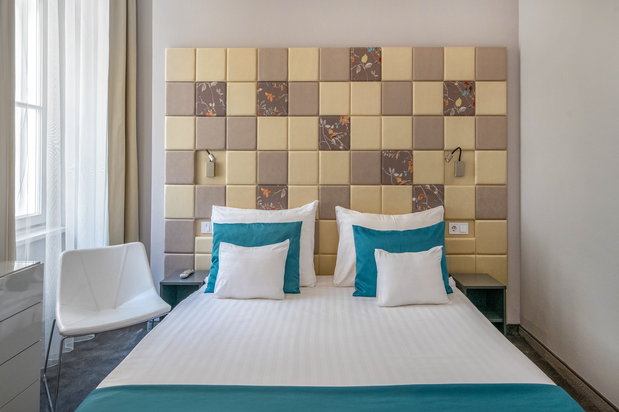 a bed with pillows and a chair in a room