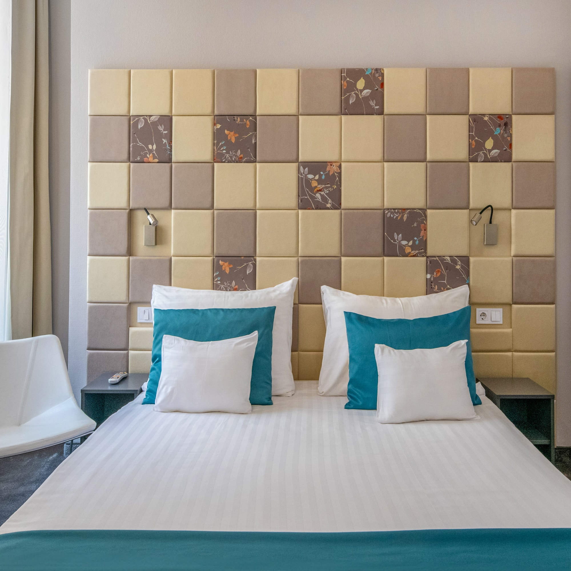 a bed with pillows and a chair in a room