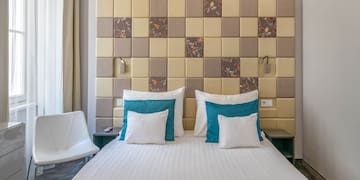 a bed with pillows and a chair in a room