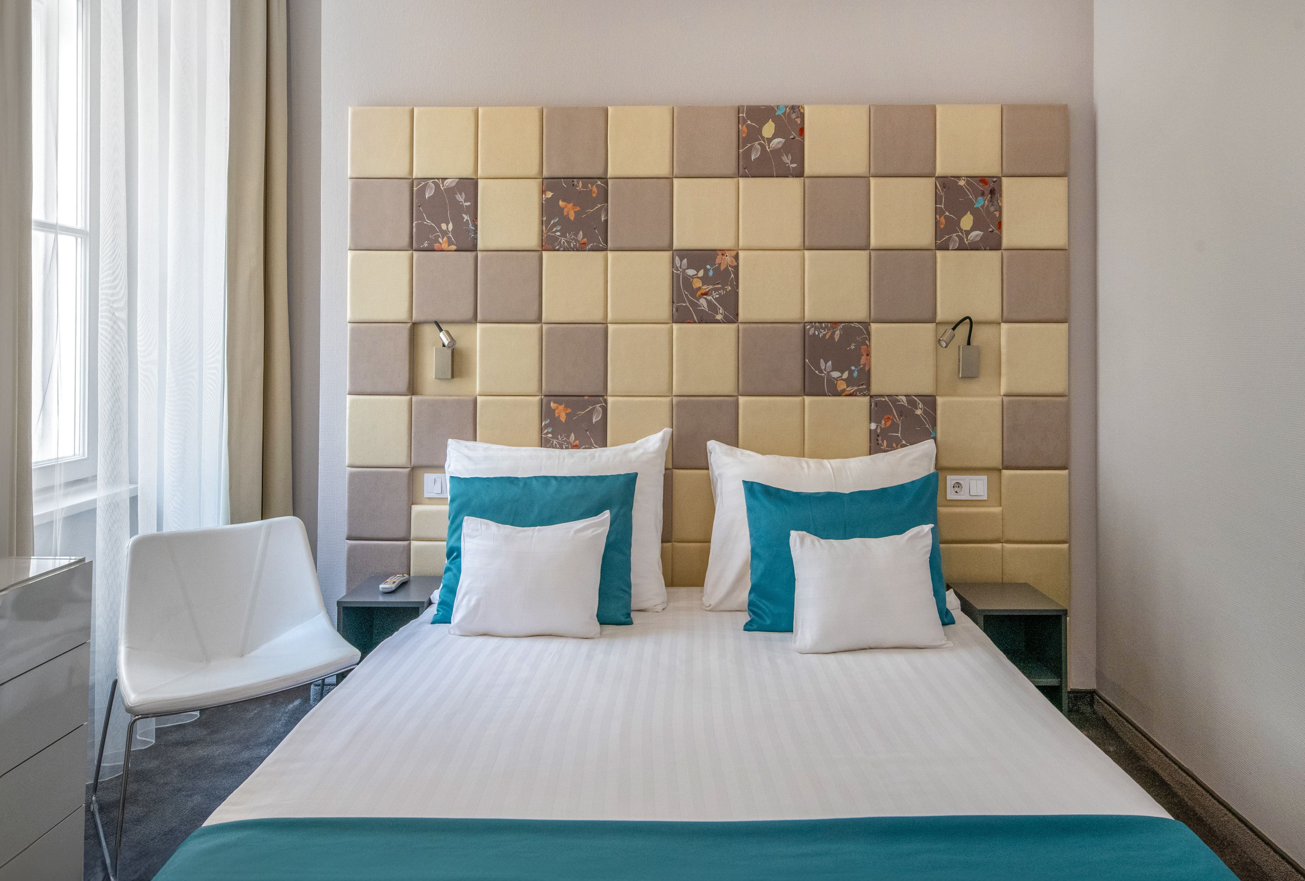 a bed with pillows and a chair in a room