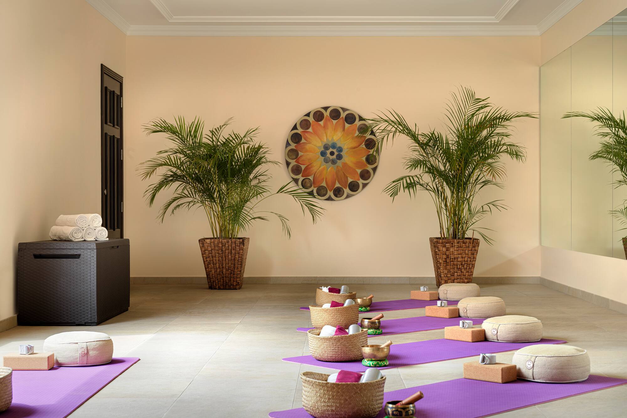 Yoga meditation studio with purple mats, cushions, and singing bowls.