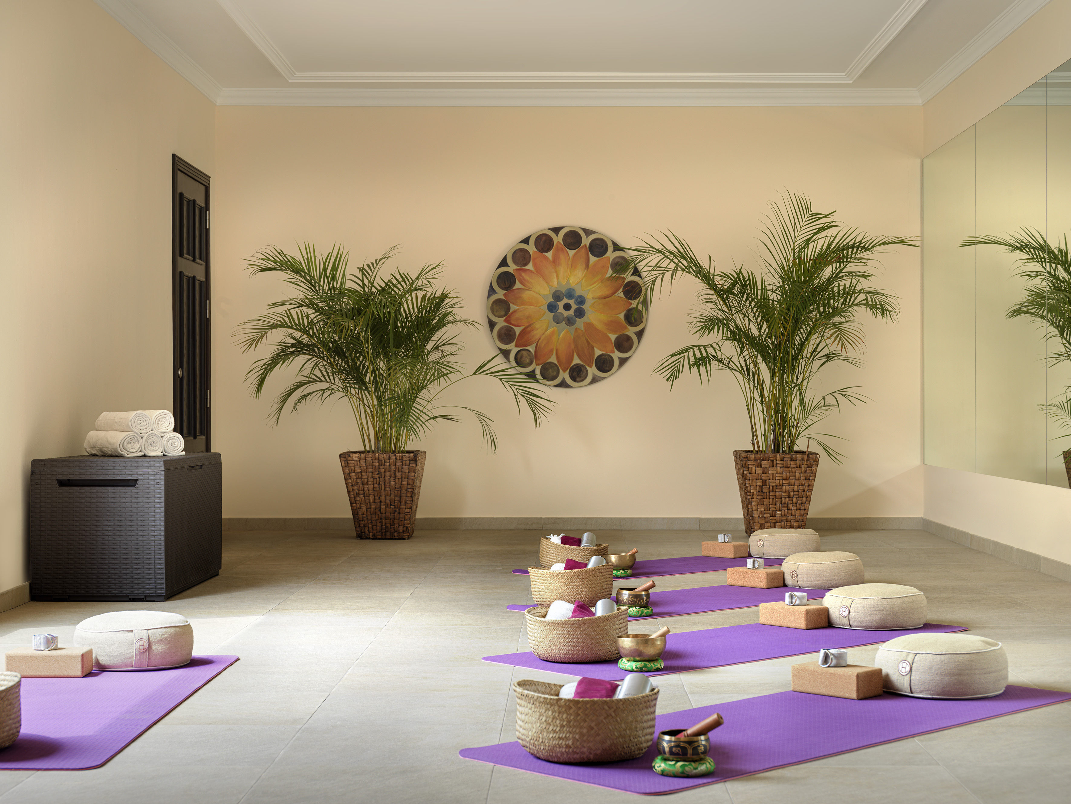 Yoga meditation studio with purple mats, cushions, and singing bowls.