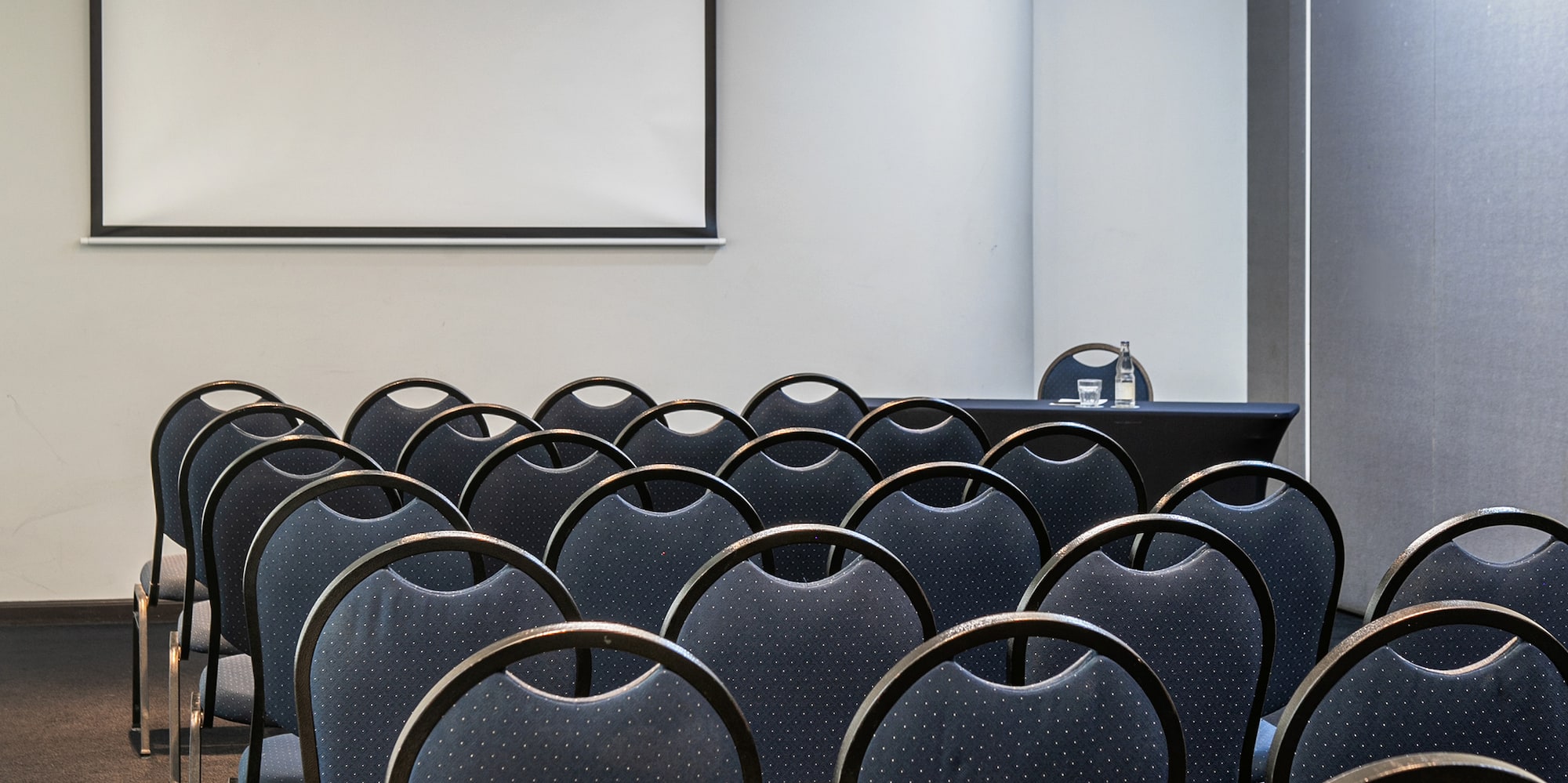 a room with chairs and a projector screen