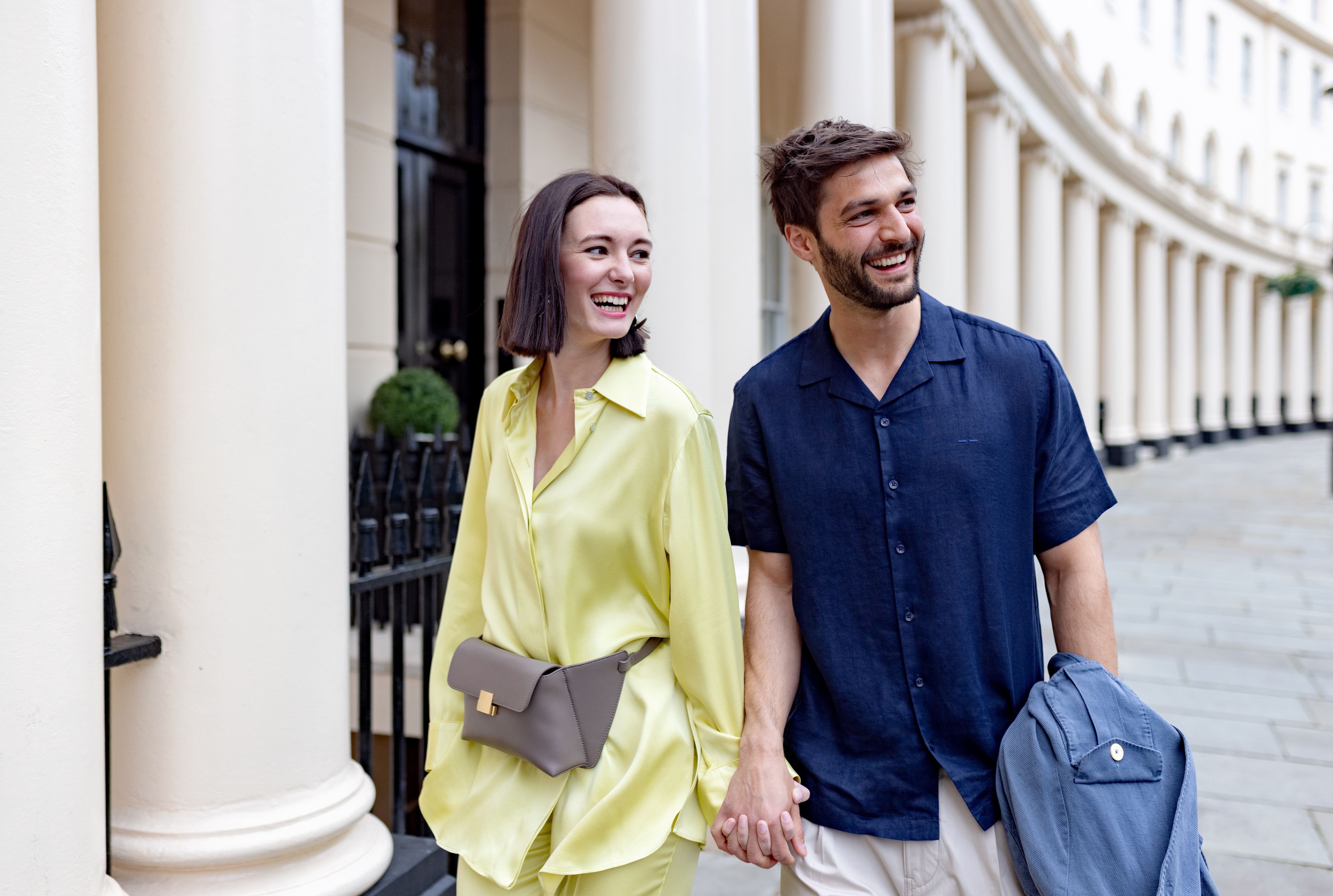 a man and woman holding hands and smiling