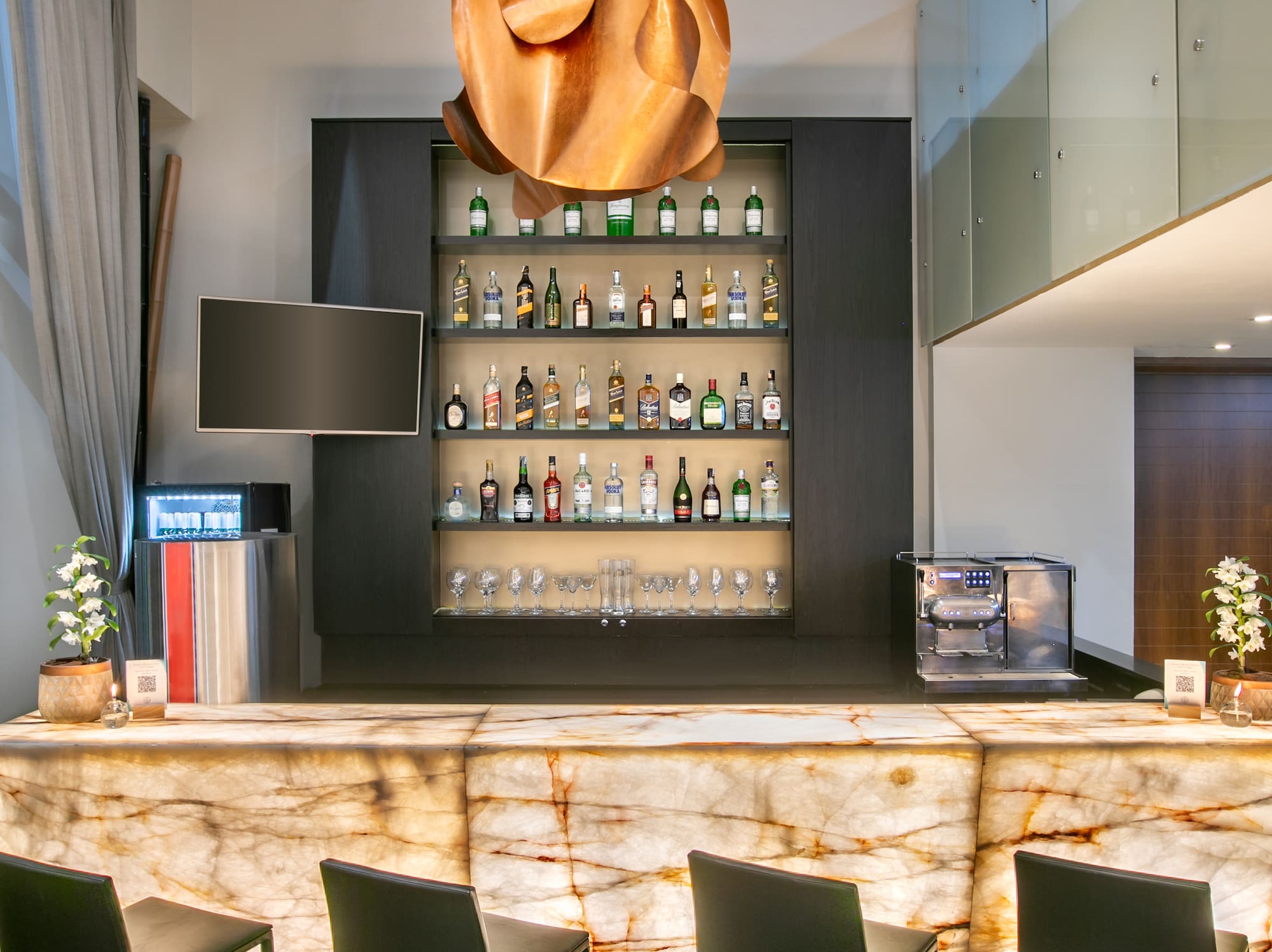 a bar with a marble counter and chairs