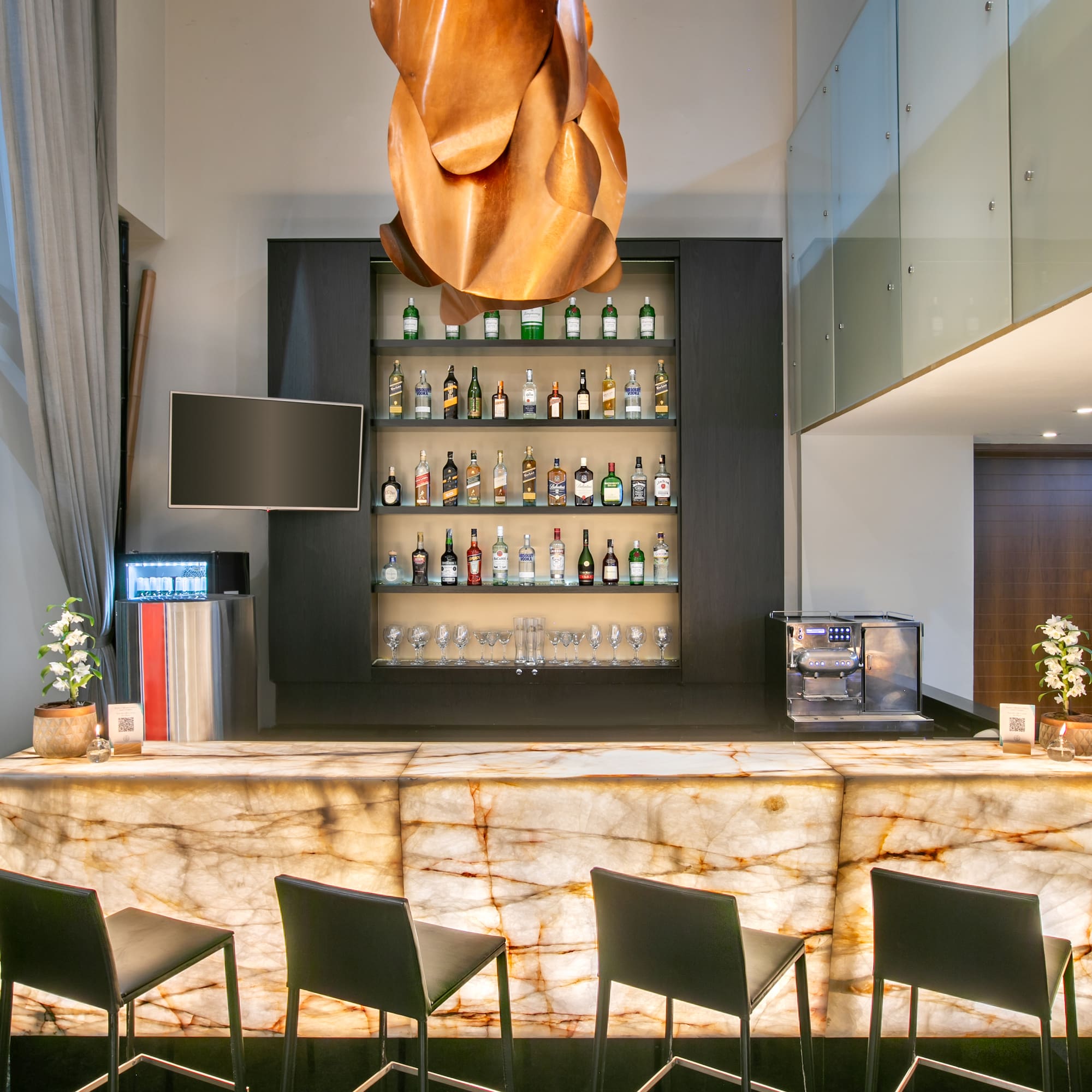 a bar with a marble counter and chairs