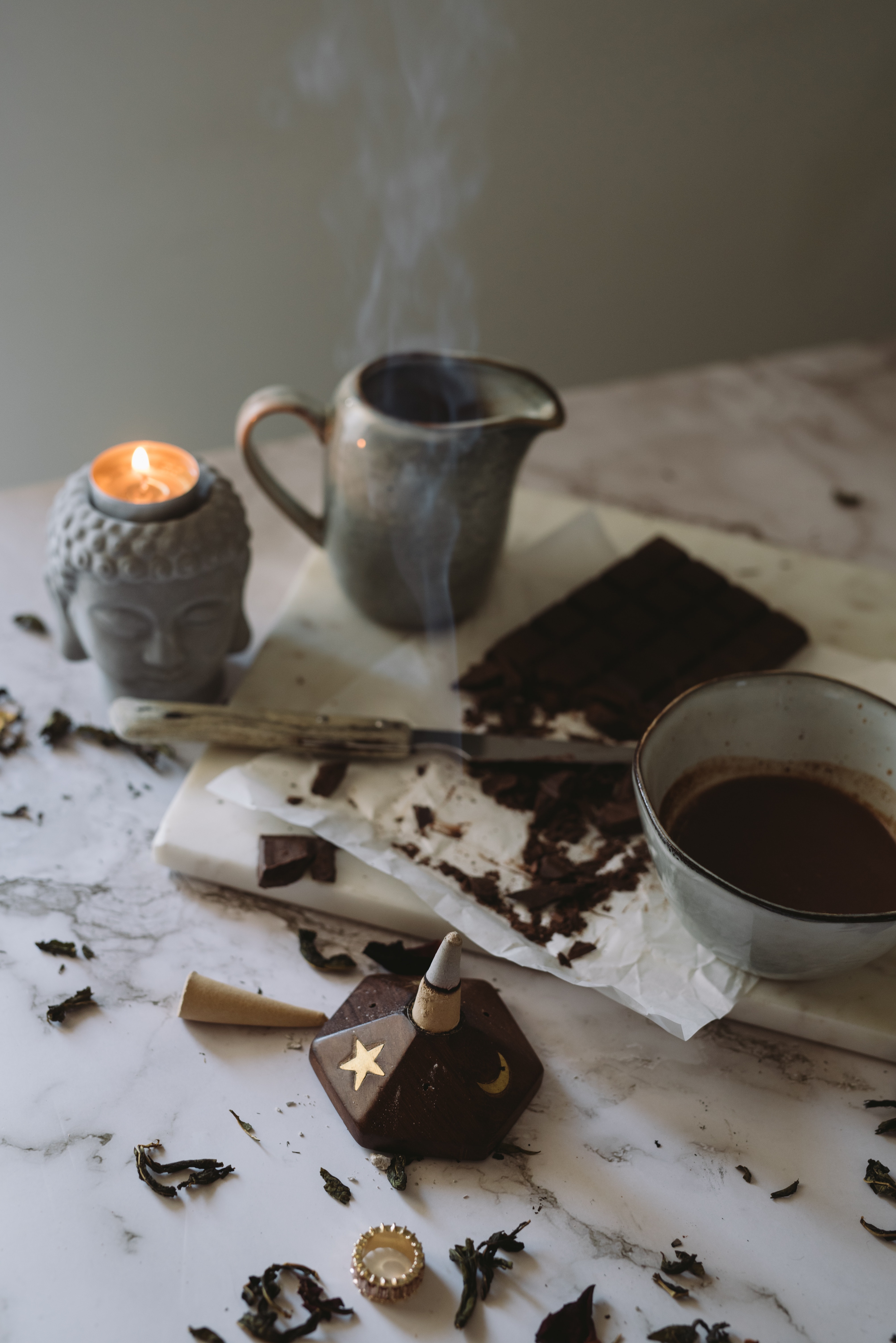 a cup of coffee and a candle on a marble surface