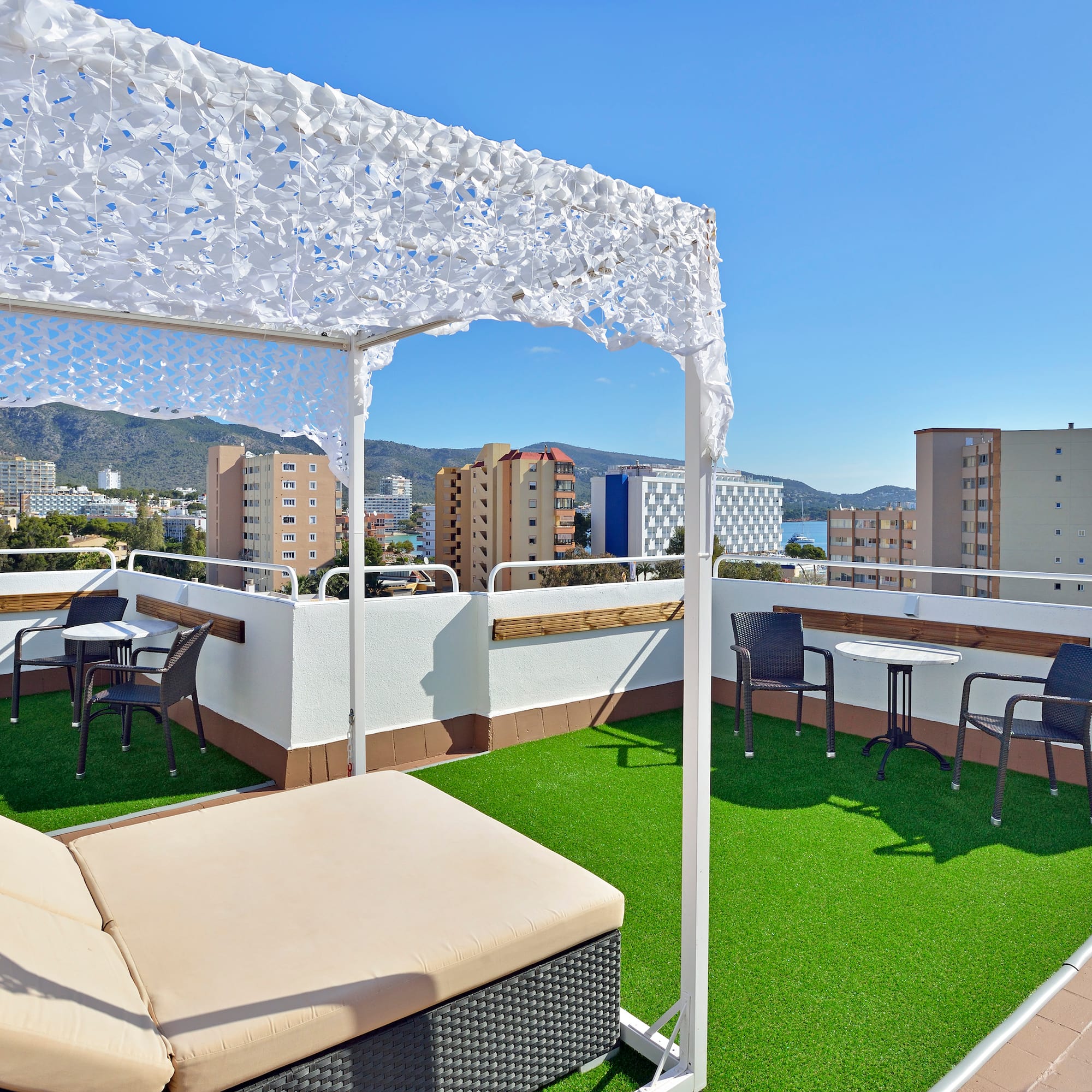 a patio with a white canopy and chairs on a rooftop
