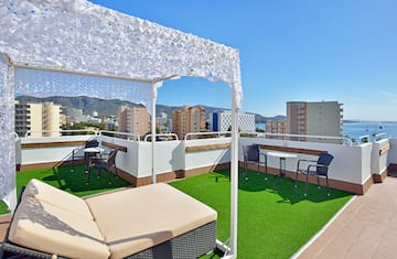 a patio with a white canopy and chairs on a rooftop