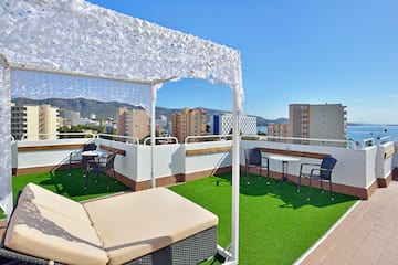 a patio with a white canopy and chairs on a rooftop