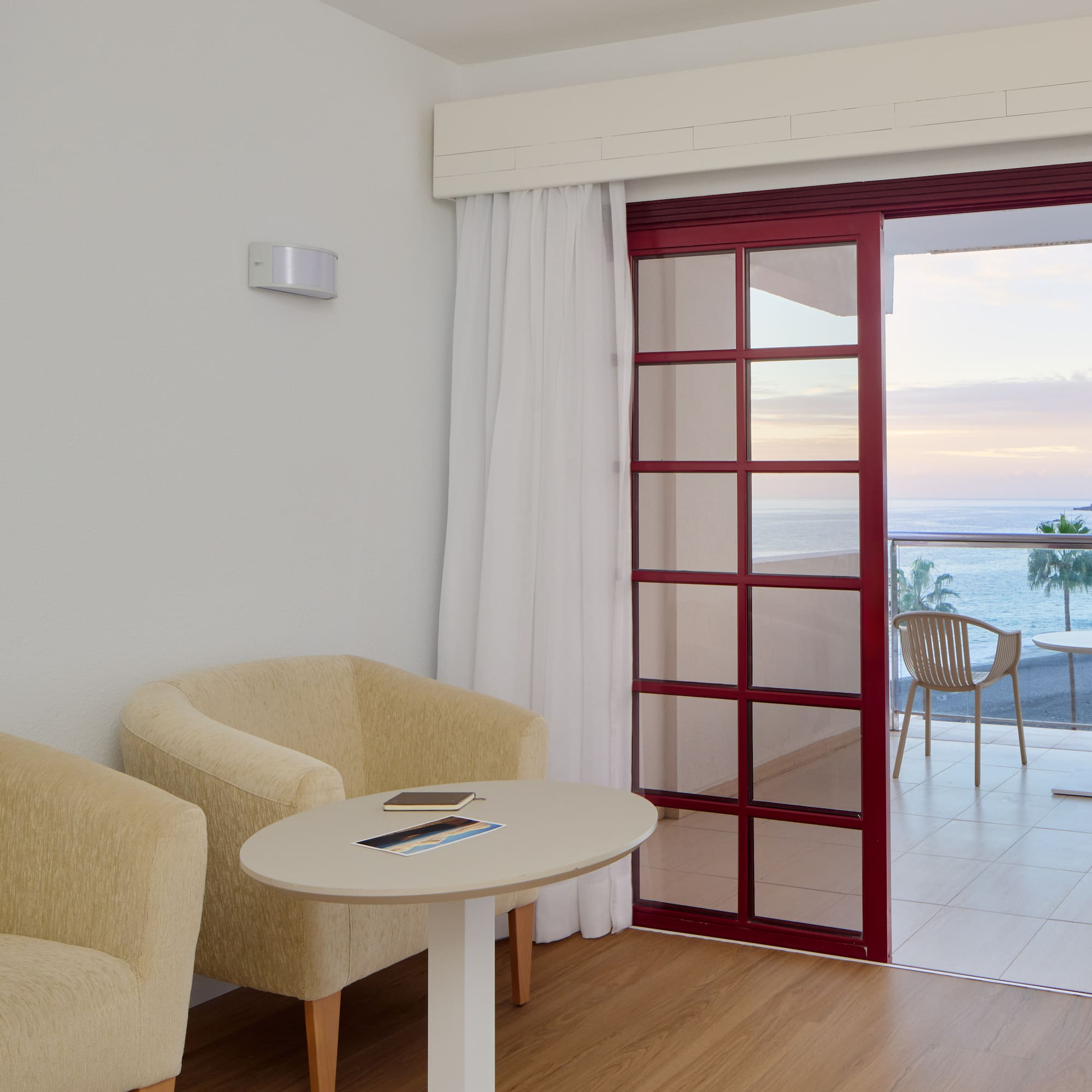 a room with a table and chairs and a glass door