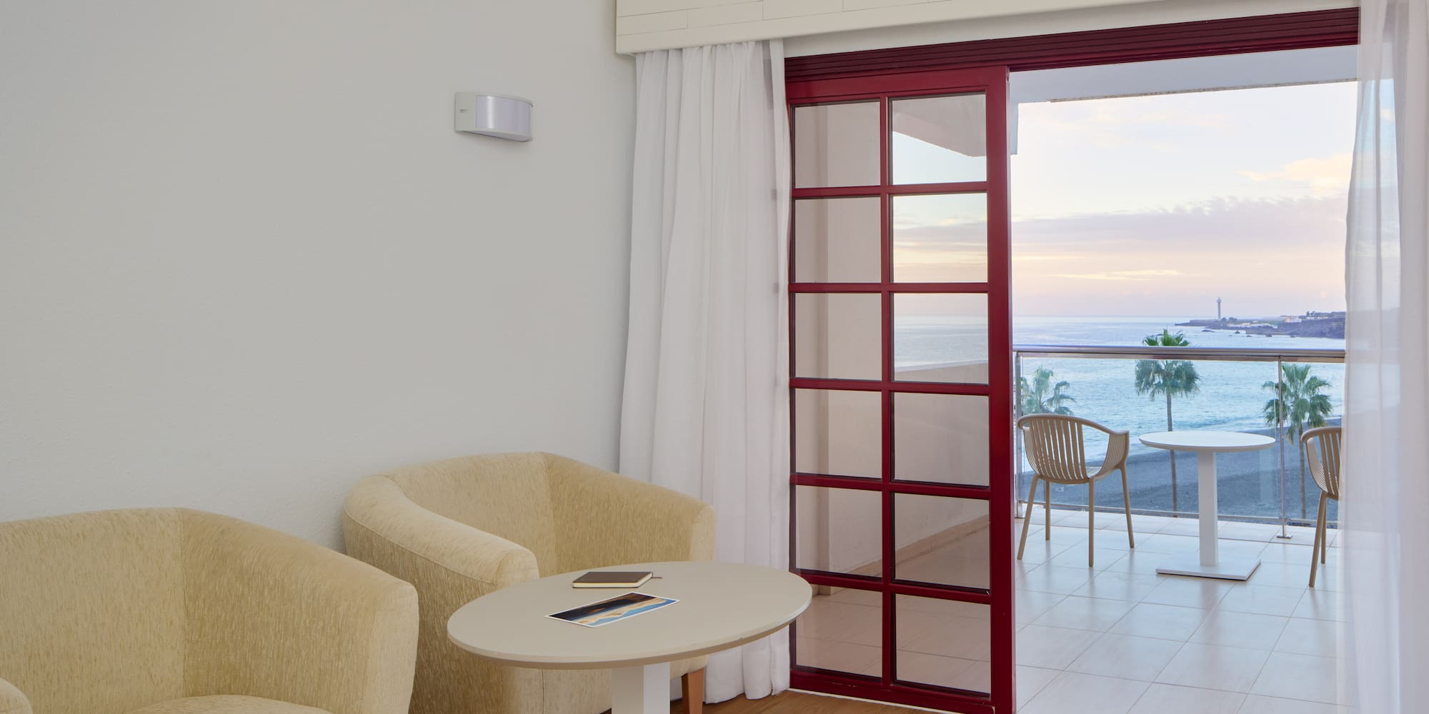 a room with a table and chairs and a glass door