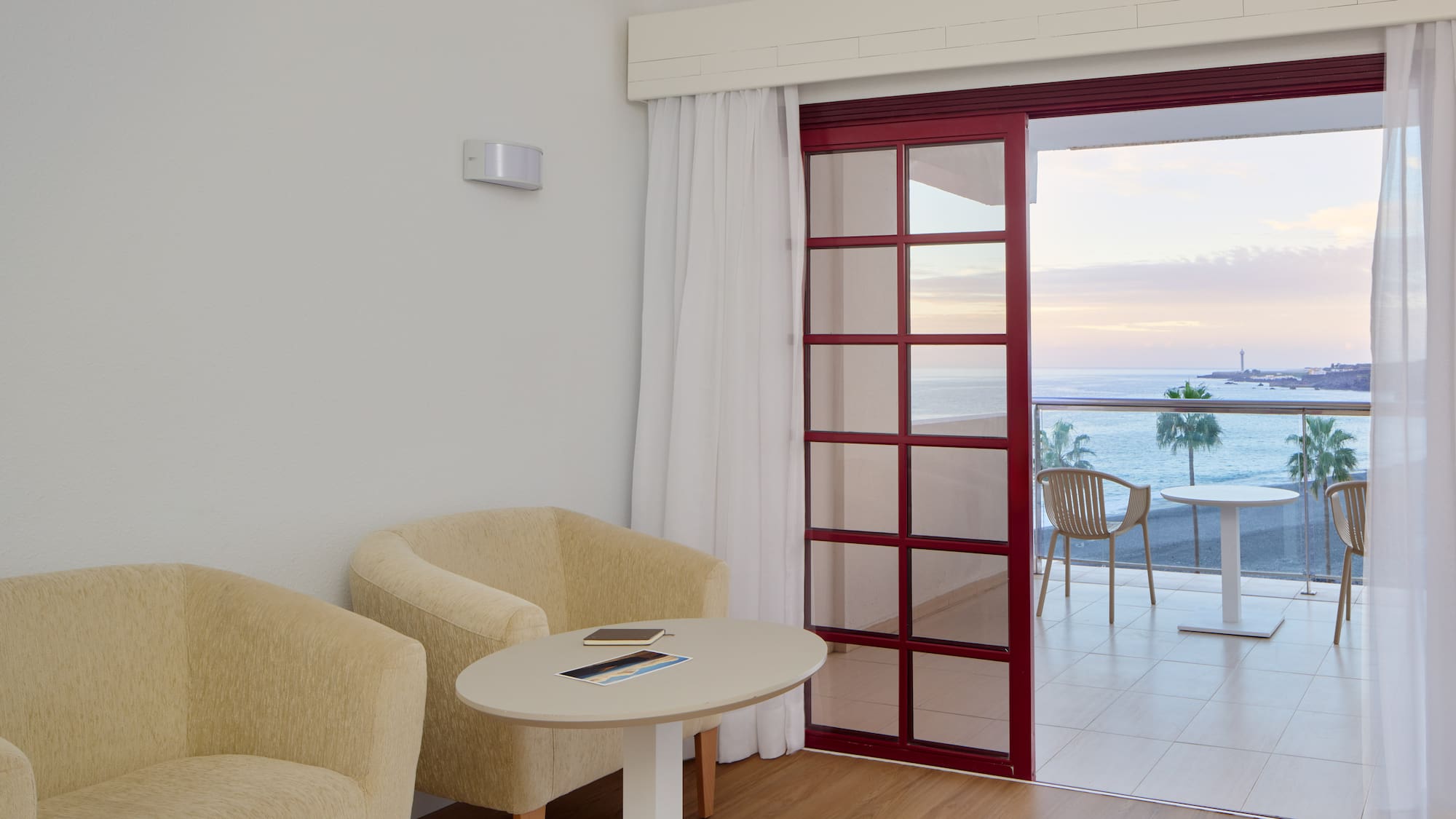 a room with a table and chairs and a glass door