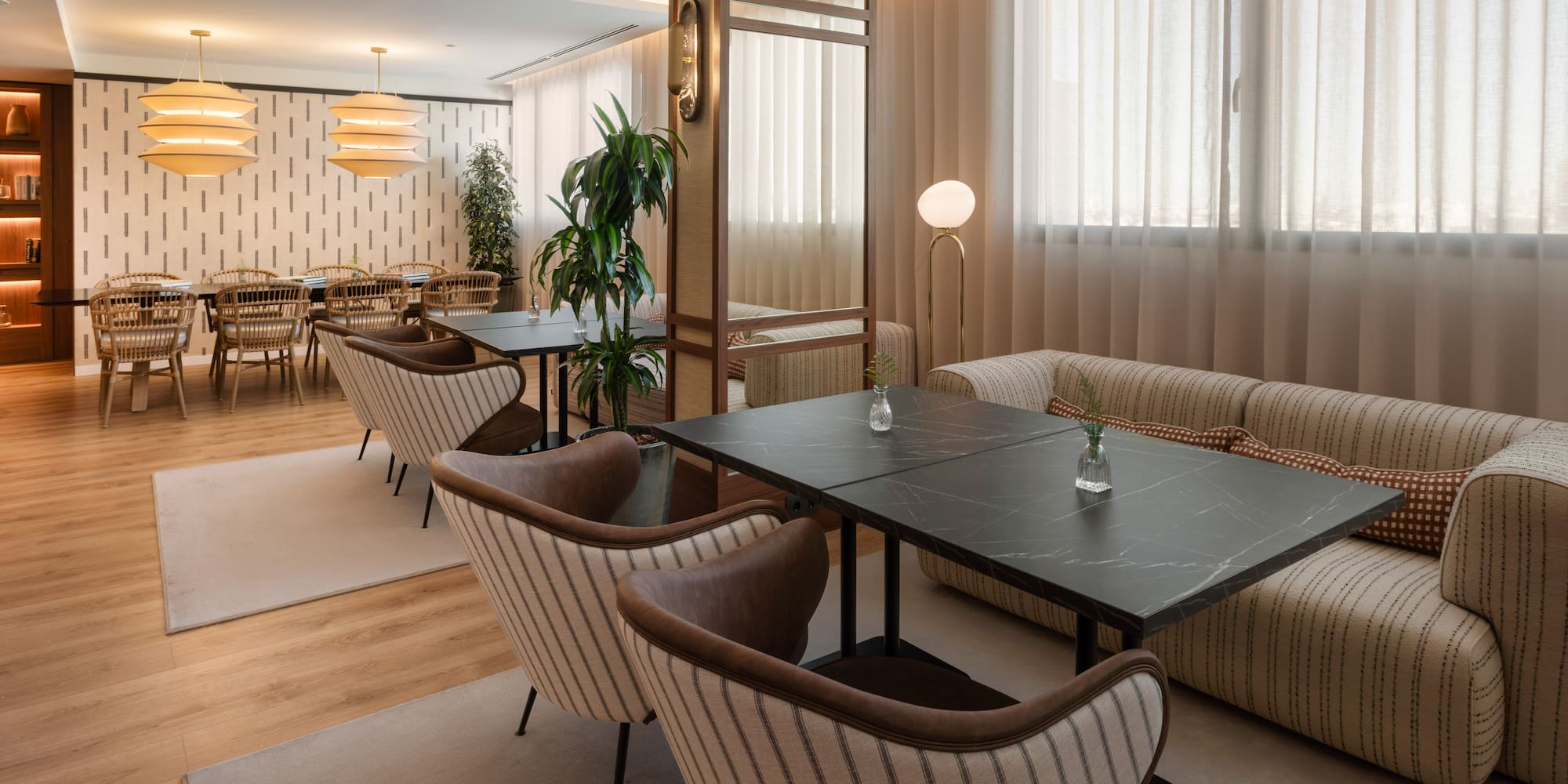 Lounge moderno con mesas, sillas, sofá y plantas. Interior de diseño elegante.