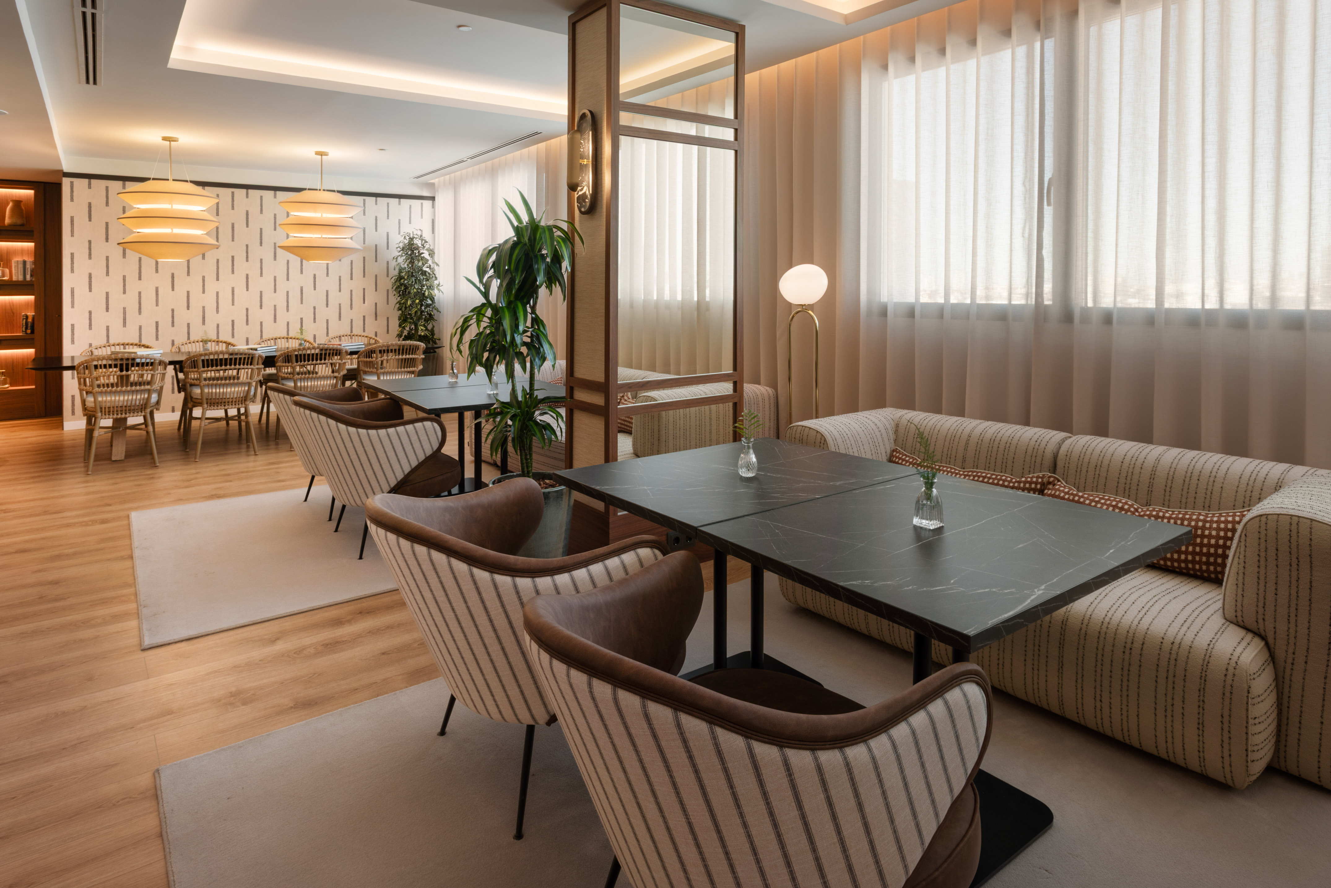 Lounge moderno con mesas, sillas, sofá y plantas. Interior de diseño elegante.