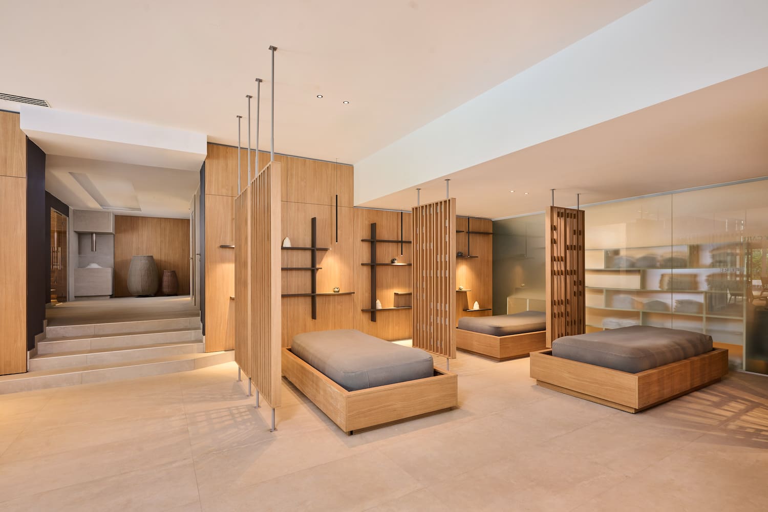 a room with multiple beds and shelves