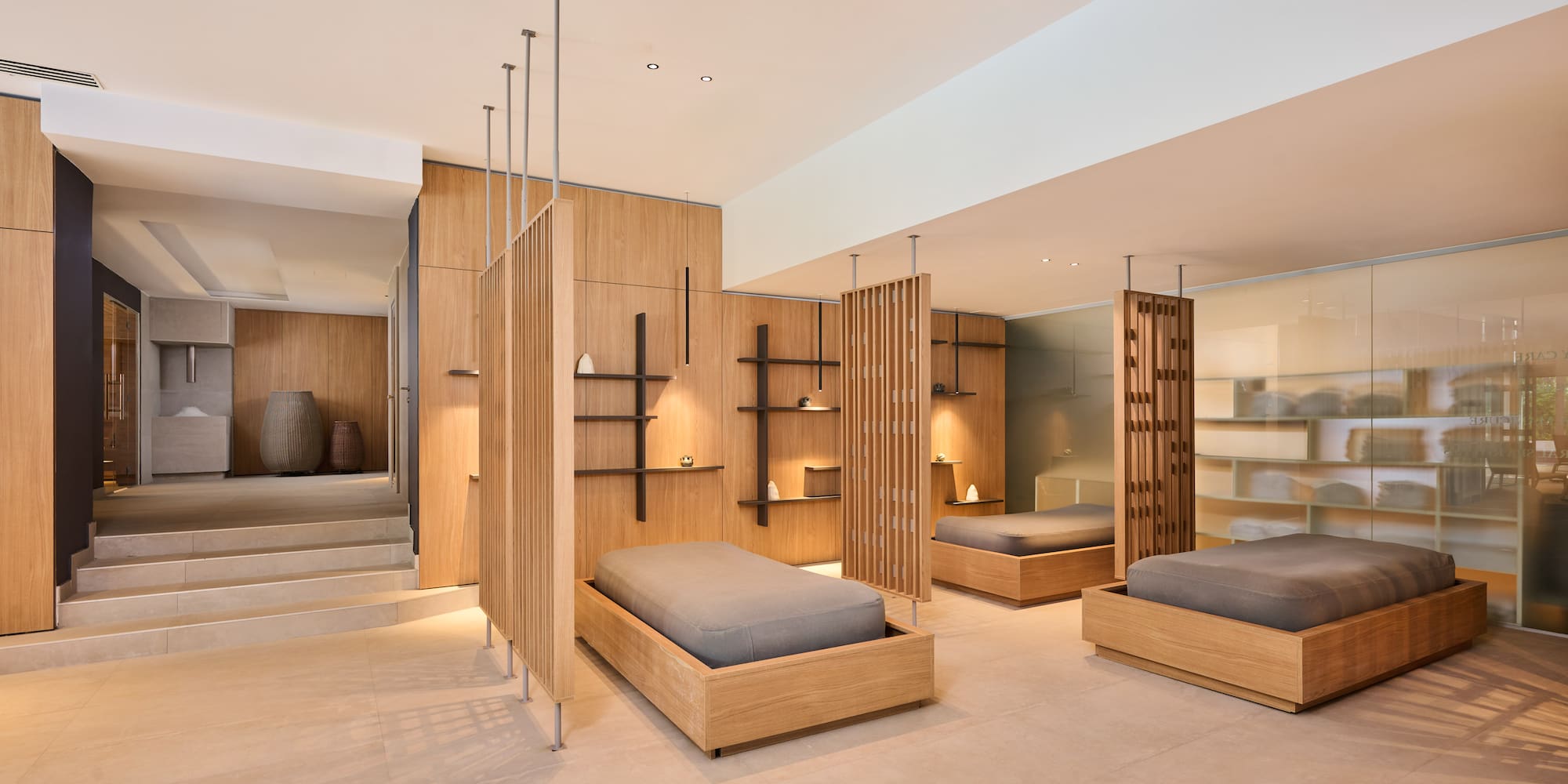 a room with multiple beds and shelves