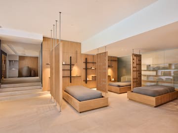 a room with multiple beds and shelves