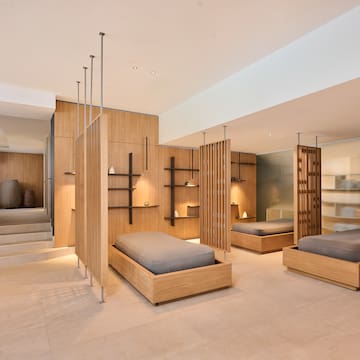 a room with multiple beds and shelves