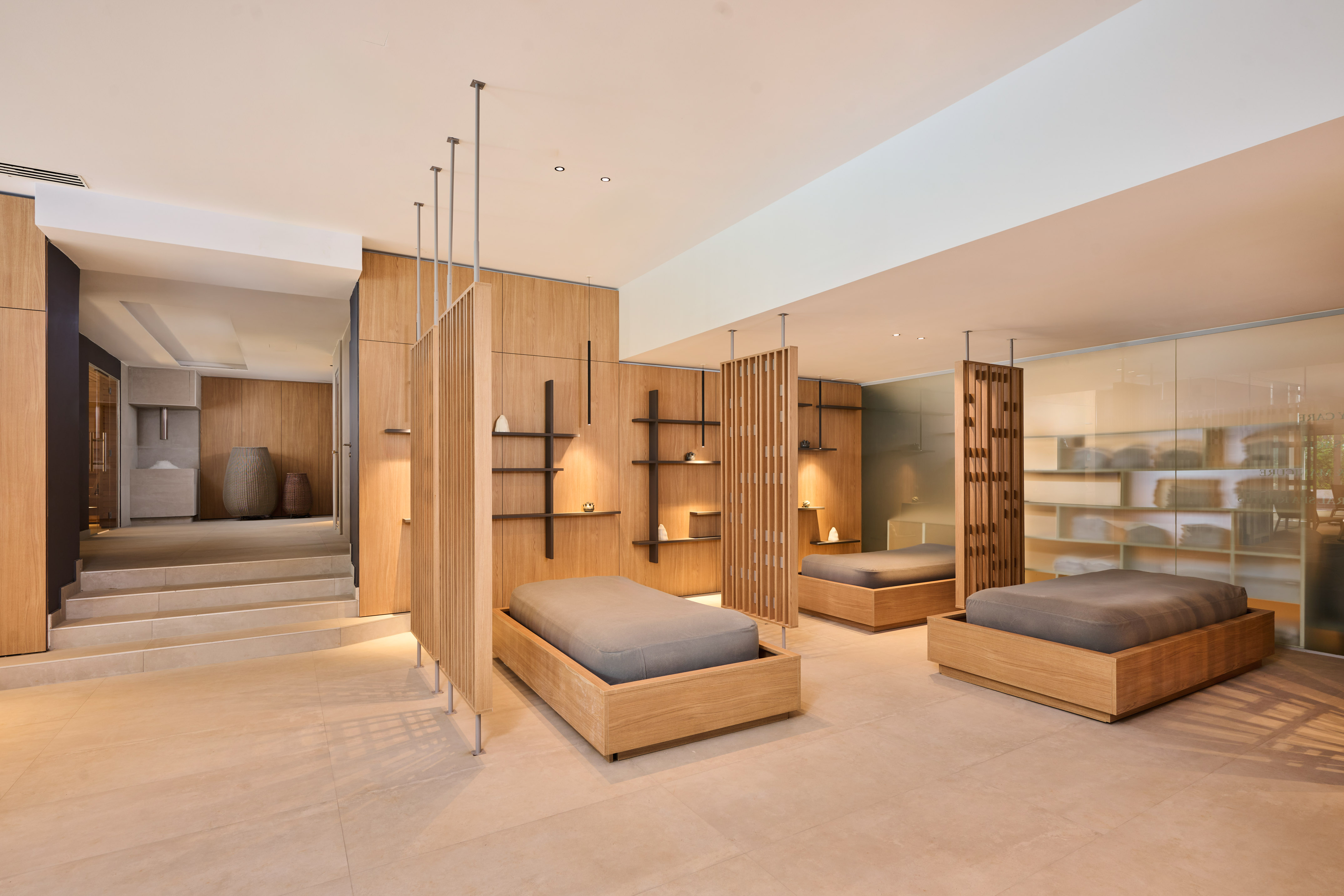 a room with multiple beds and shelves