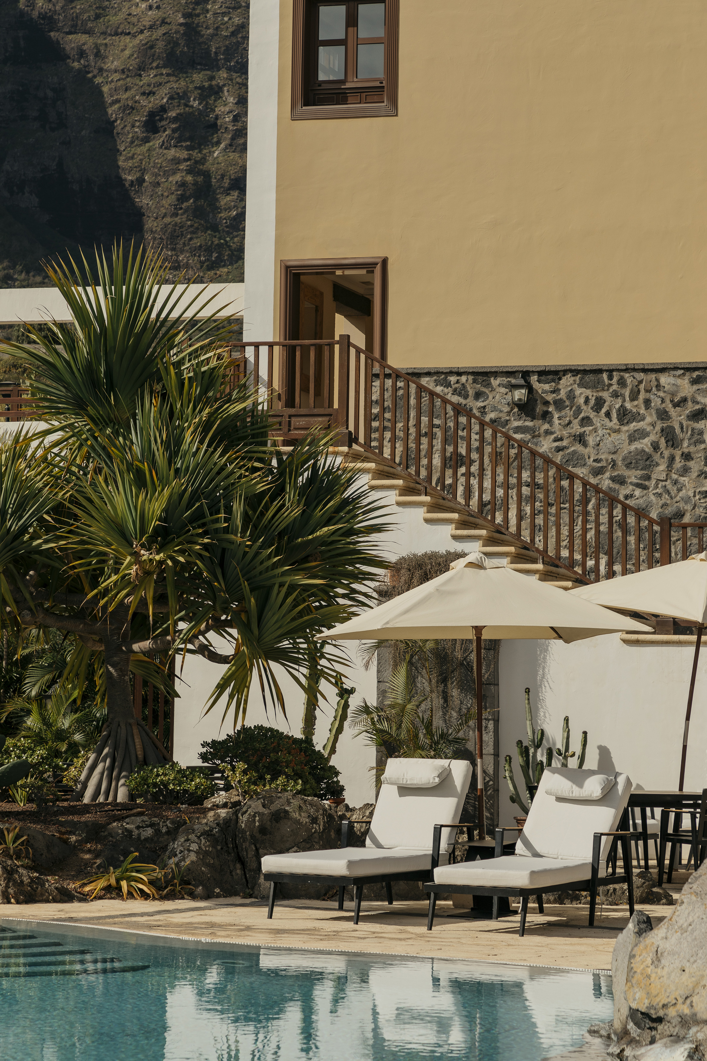a lounge chairs and umbrellas next to a building