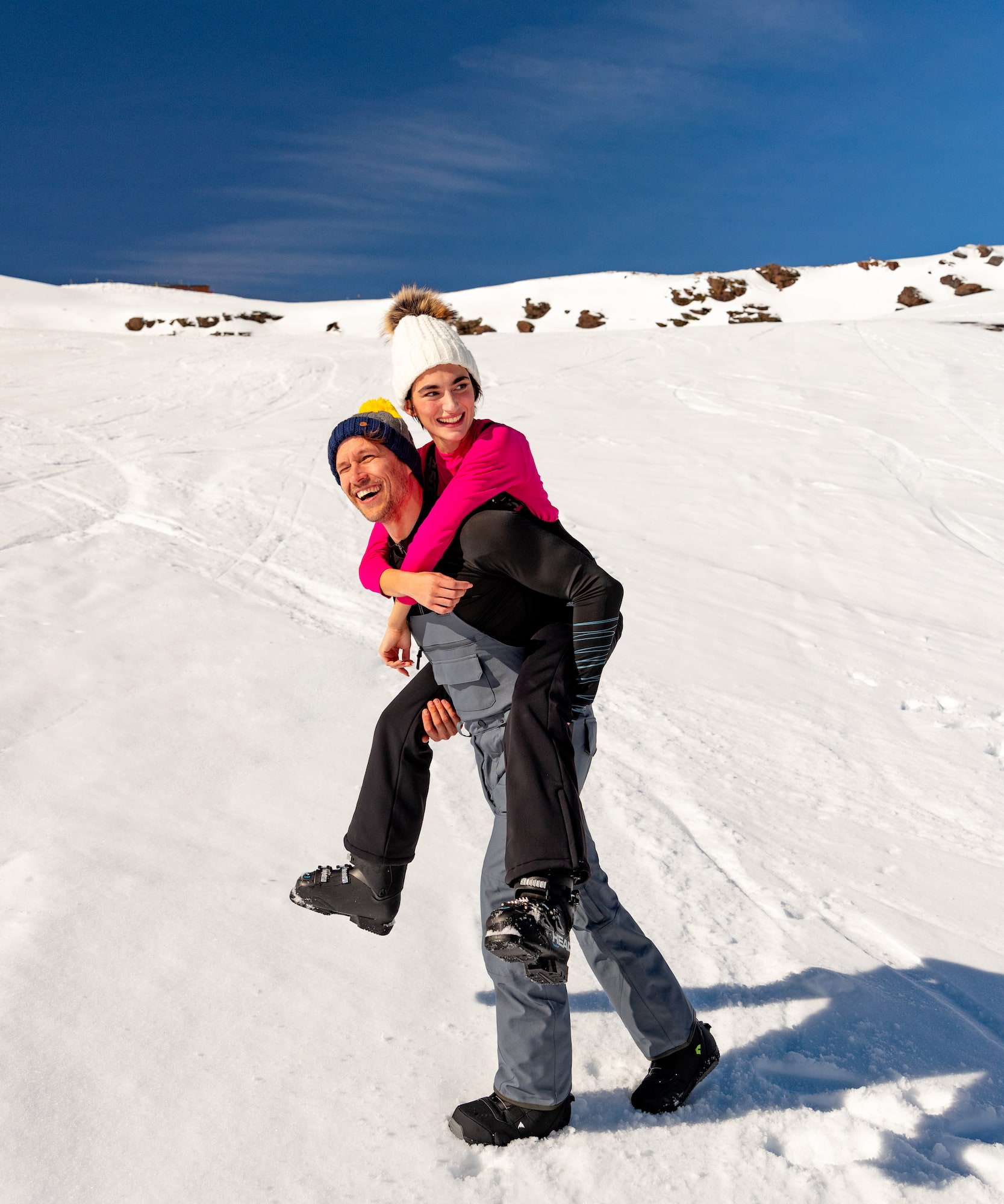 a man carrying a woman on his back in the snow
